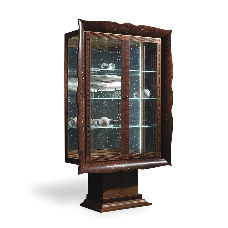 It has a rounded structure, reminding one of a picture frame, made of wood with mother-of-pearl dot inserts. The crystal doors feature a rich inlaid filleting. The back is mirror with, on request, led lighting similar to luminous little spots. Also