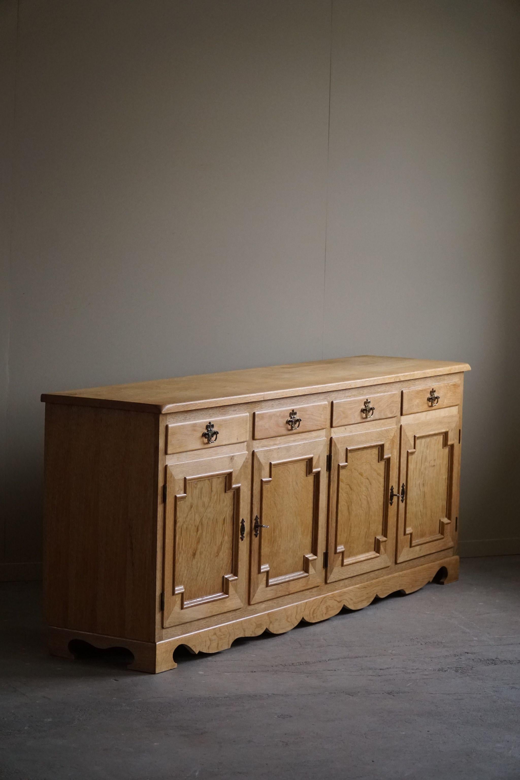 A fine rectangular classic buffet cabinet / sideboard in oak with brass handles. Made by a Danish cabinetmaker in the 1960s. Beautiful sculptural front design and lovely warm patina.
This piece is in a very good vintage condition.

A fine brutalist