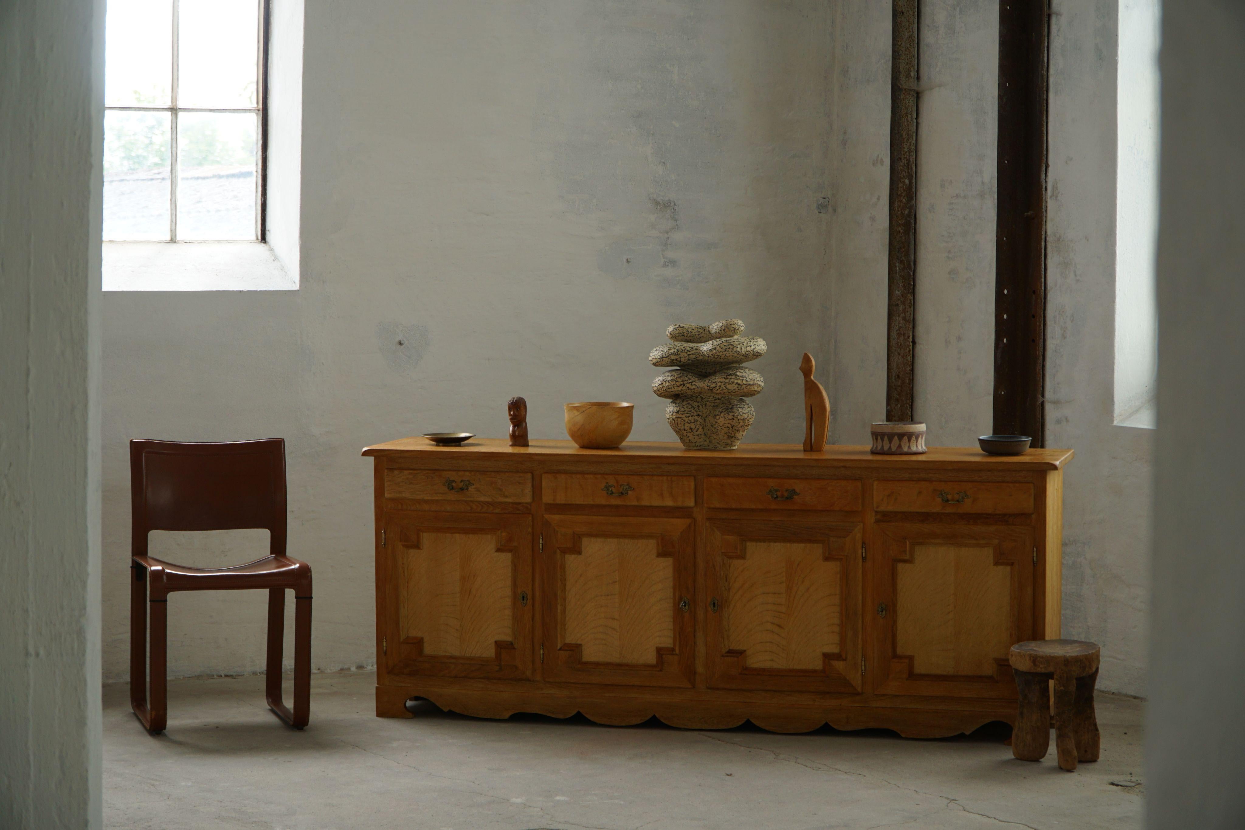 Un raffinato mobile buffet classico rettangolare / credenza in Oak con maniglie in ottone. Realizzato da un ebanista danese negli anni '1960. Bellissimo design scultoreo del frontale e deliziosa patina calda.
Questo pezzo è in ottime condizioni