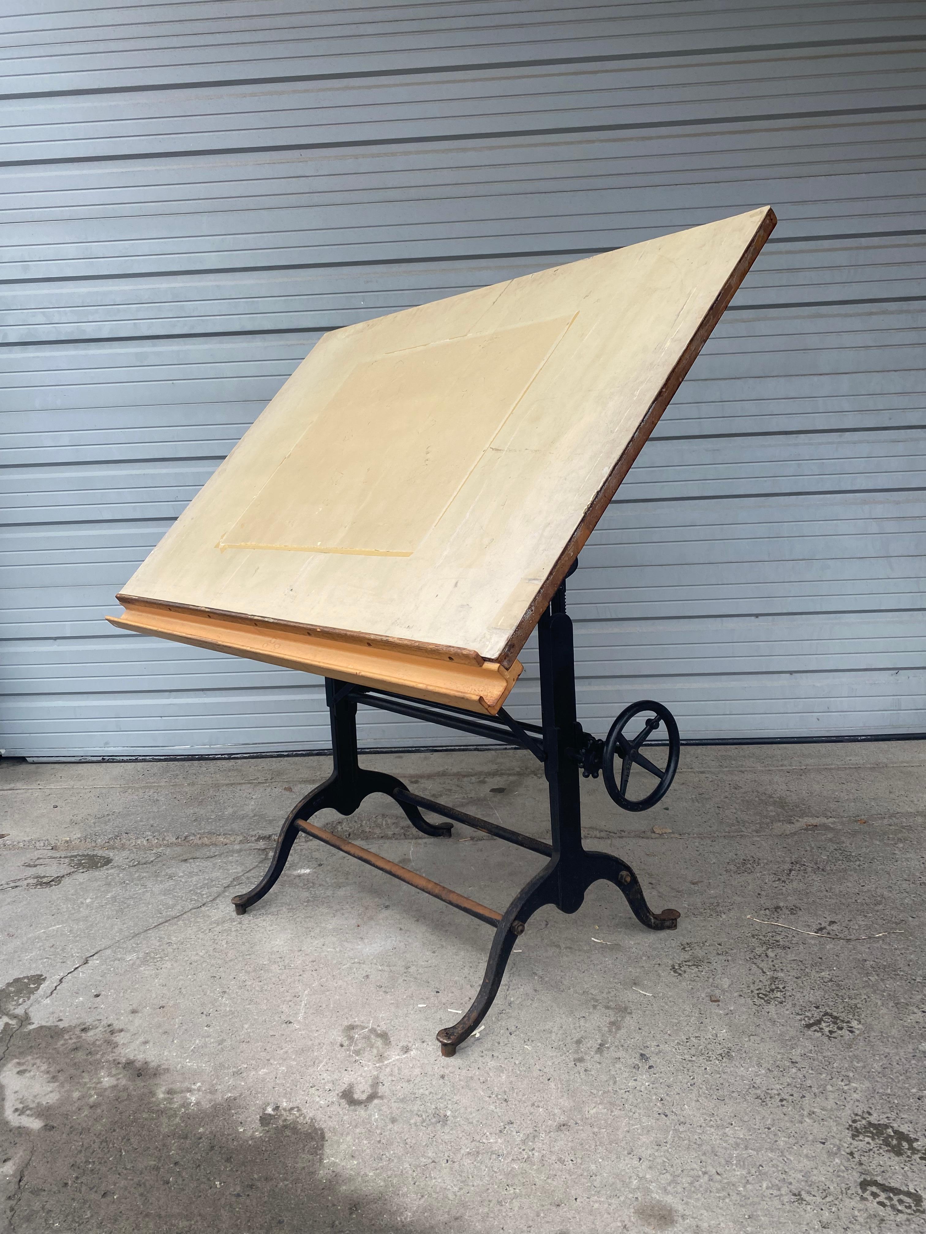 Early 1900s antique wood and cast iron drafting table by the Frederick Post Co. of Chicago/ San Fransisco. T heavy-duty, fully adjustable table base is in nice original condition. Table-top surface covered with old linoleum Fully adjustable height