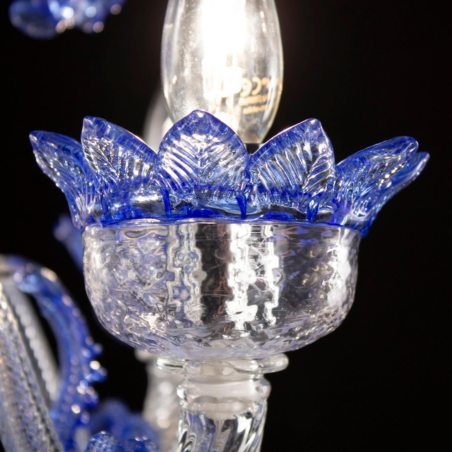 Klassischer 5-armiger Kronleuchter aus klarem und blauem Murano Glas mit Ringen von Multiforme.
Der klassische Murano-Glaslüster, wie er in der kollektiven Vorstellung ist. Wie viele andere Kronleuchter aus unseren Kollektionen wurde auch V-Classic