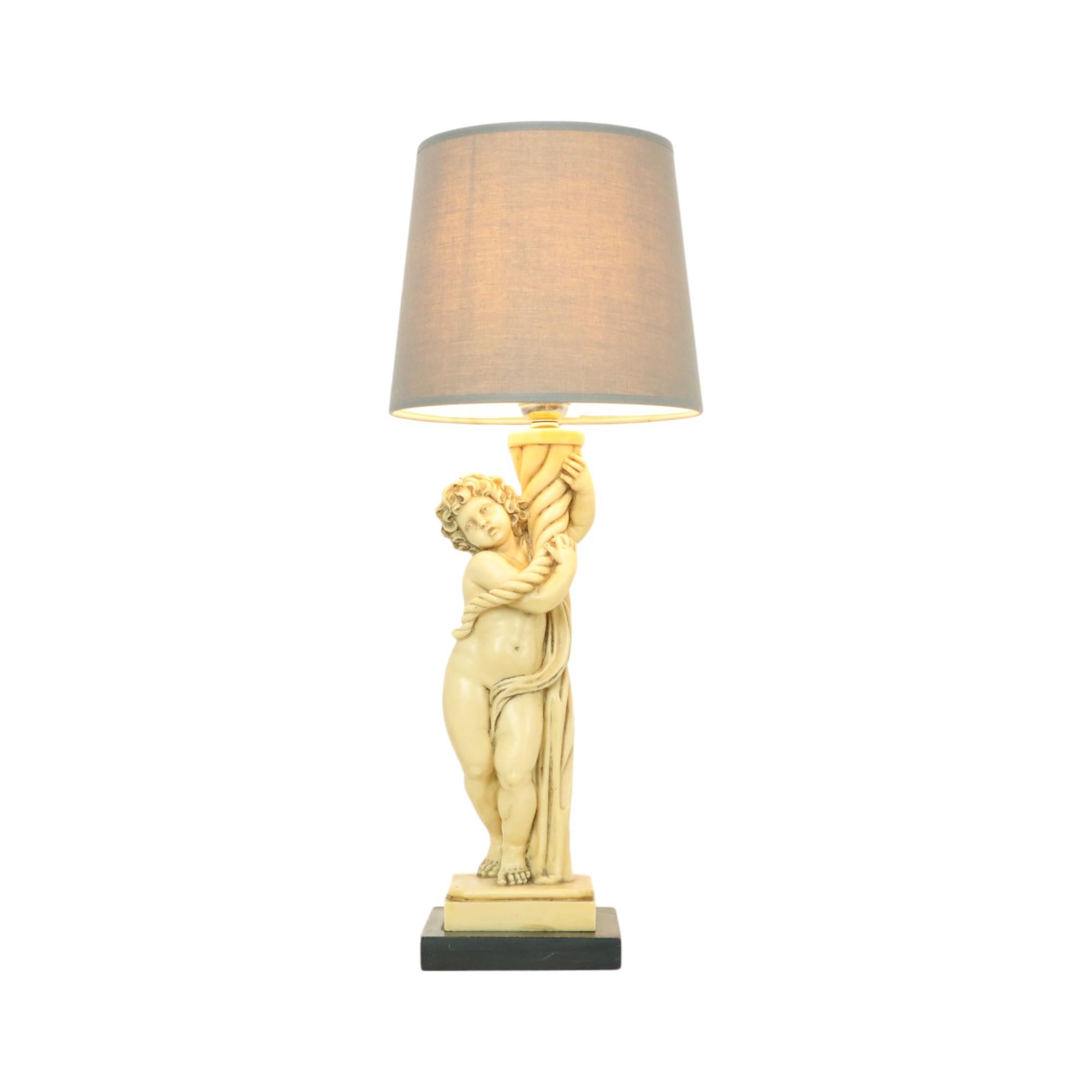 Vintage-Lampe, Tischlampe mit Lampenschirm, Darstellung eines Engels, einer Putte oder eines Cherubs, auf einem quadratischen schwarzen Harzsockel, signiert A. Santini (1910-1975), Italien 1950er Jahre.

Hergestellt aus Gießharz oder Harz mit Zusatz