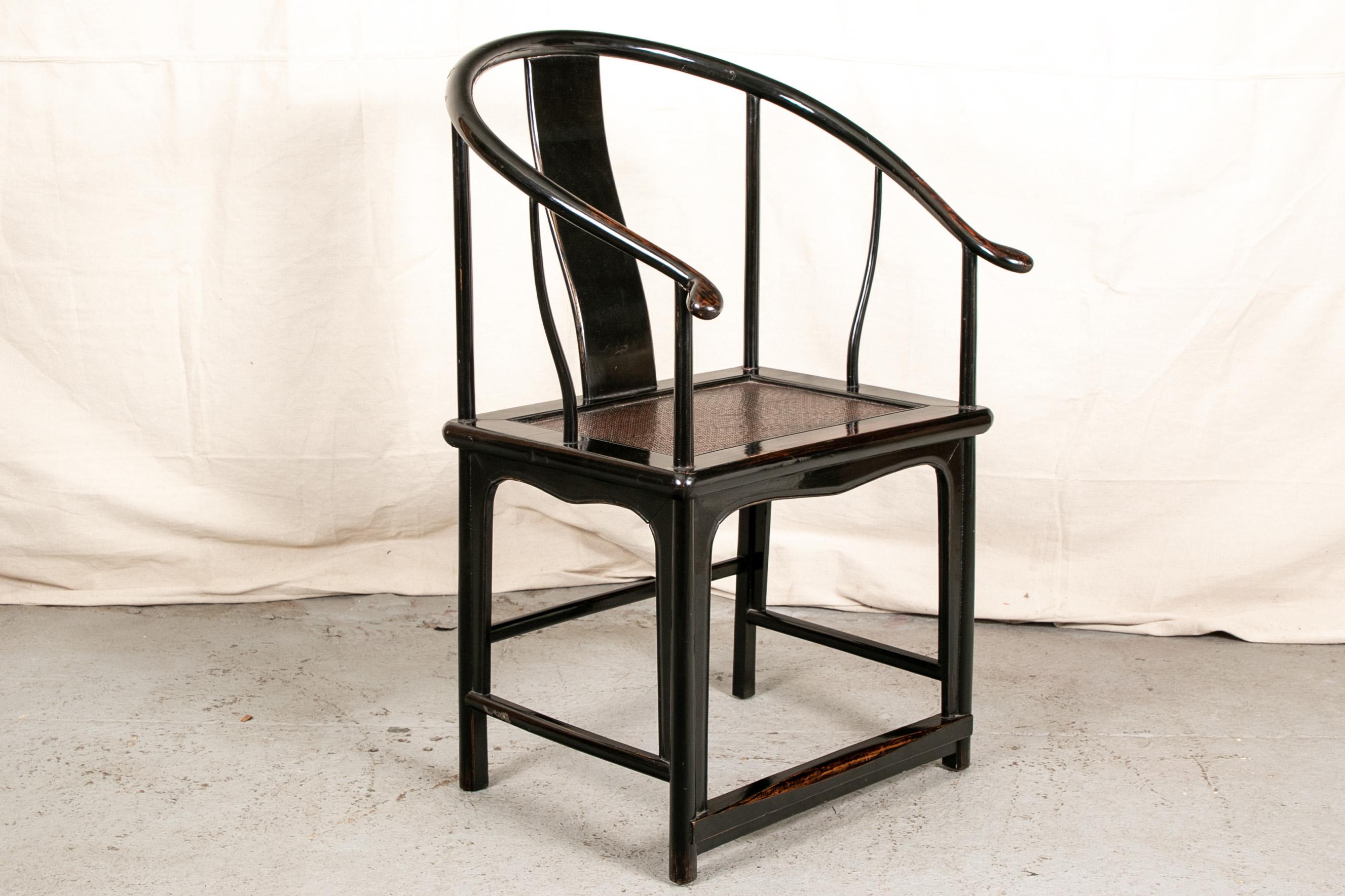 Classic Chinese armchair, ebonized rosewood in the Classic shape with wide recessed seat with brown wicker panel, scrolled arms, shaped lower frame with inset half round legs. Four stretchers. In a fine patina. 

Condition: Expected wear and signs