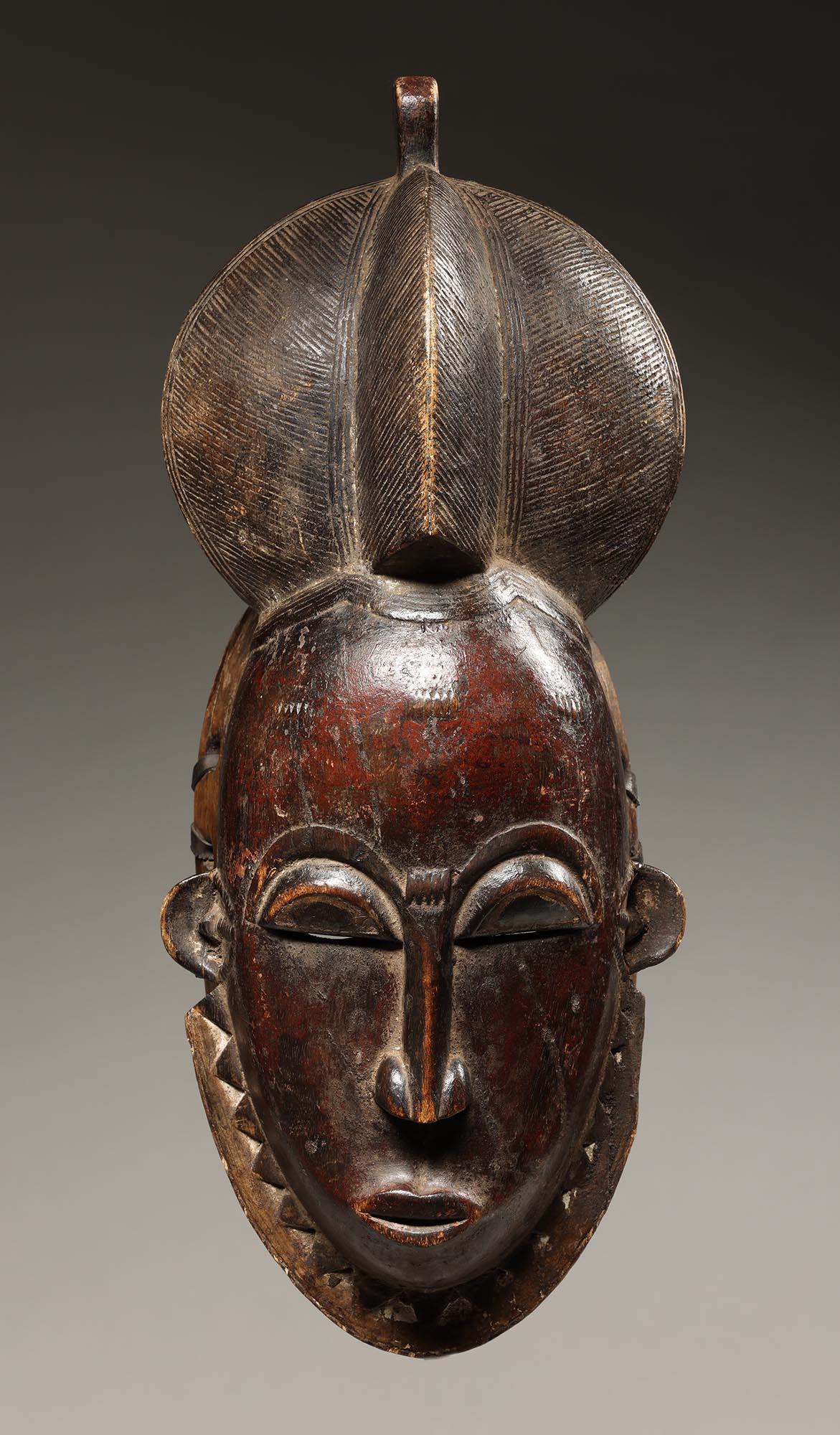 Classic danced deep red-black Baule mask, with raised three part finely incised hair, small facial scarifications on the forehead.  From Ivory Coast, Africa, mid 20th century

It is in good condition, appropriate for its age, use, and medium. Scuffs