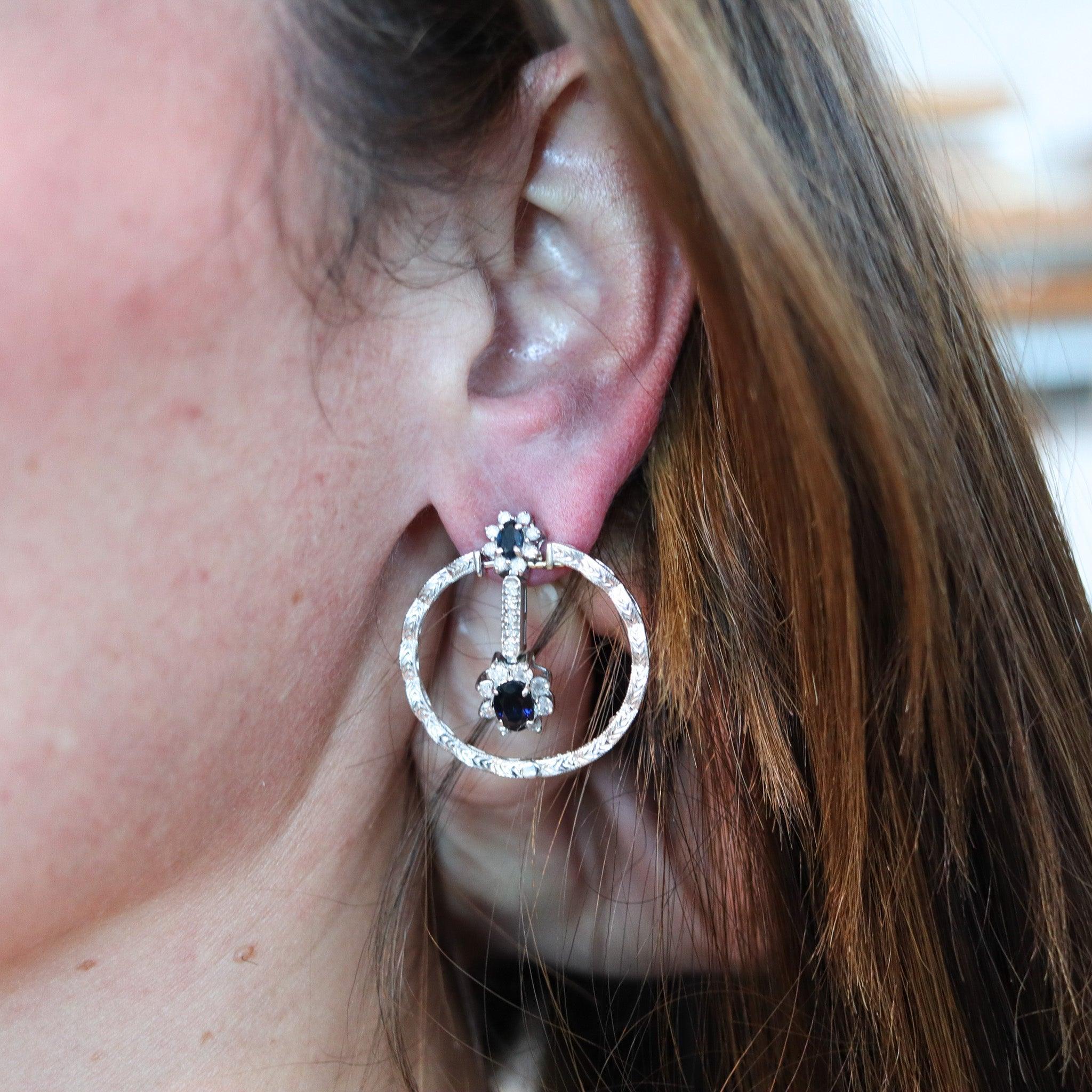 Pair of classic dangles drops earrings.

Beautiful classic pair of dangles drops earrings crafted in white gold of 18 karats with art deco patterns. The earrings are composed by two parts, fully movables and are embellished with seventy-eight