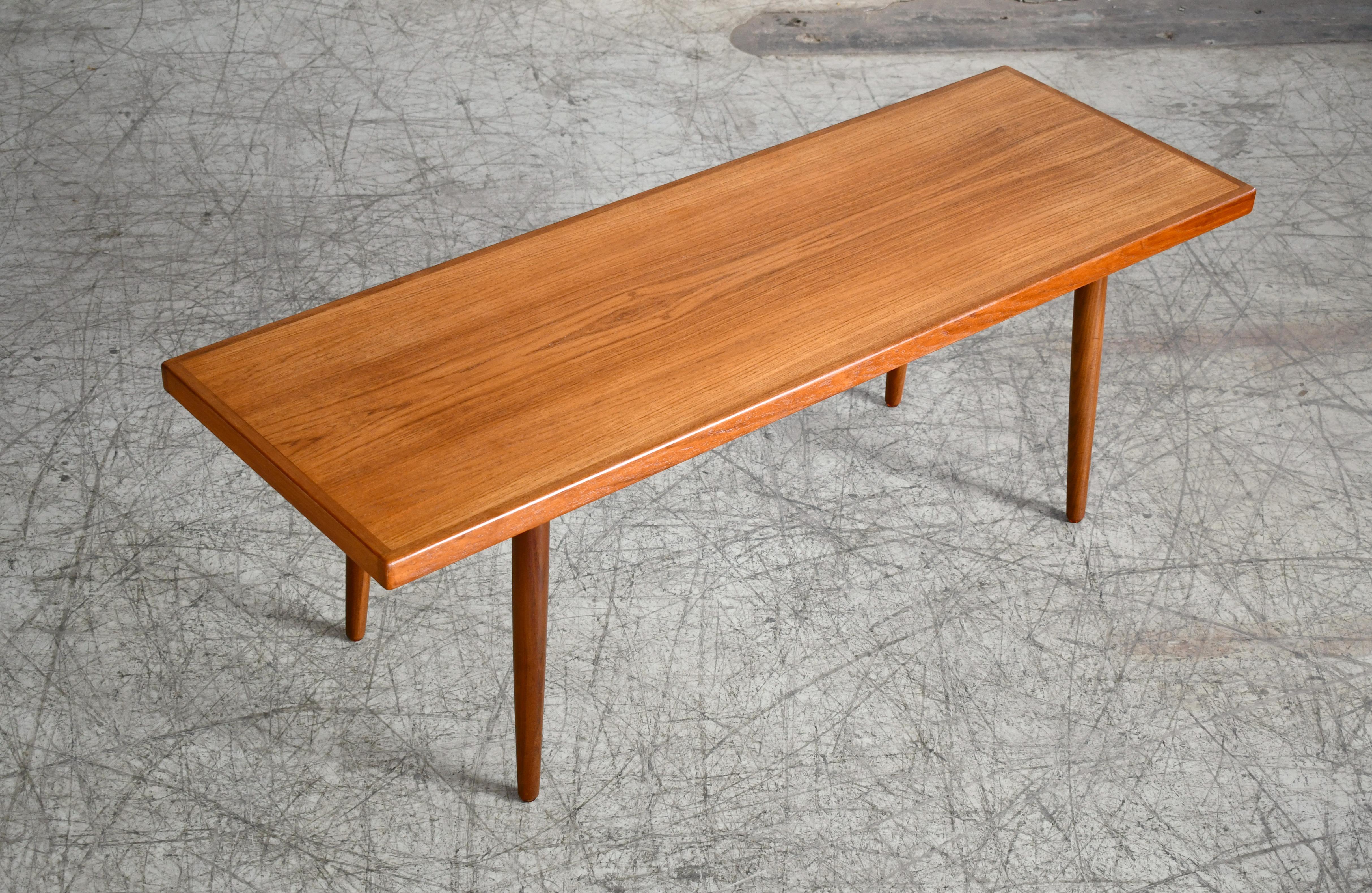 Beautiful classic Danish teak coffee table with very clean simple lines yet very refined and stylish. Very reminiscent of some of the tables designed by Peter Hvidt for France and Daverkosen. 
Crafted in teak veneer with elaborate use of solid