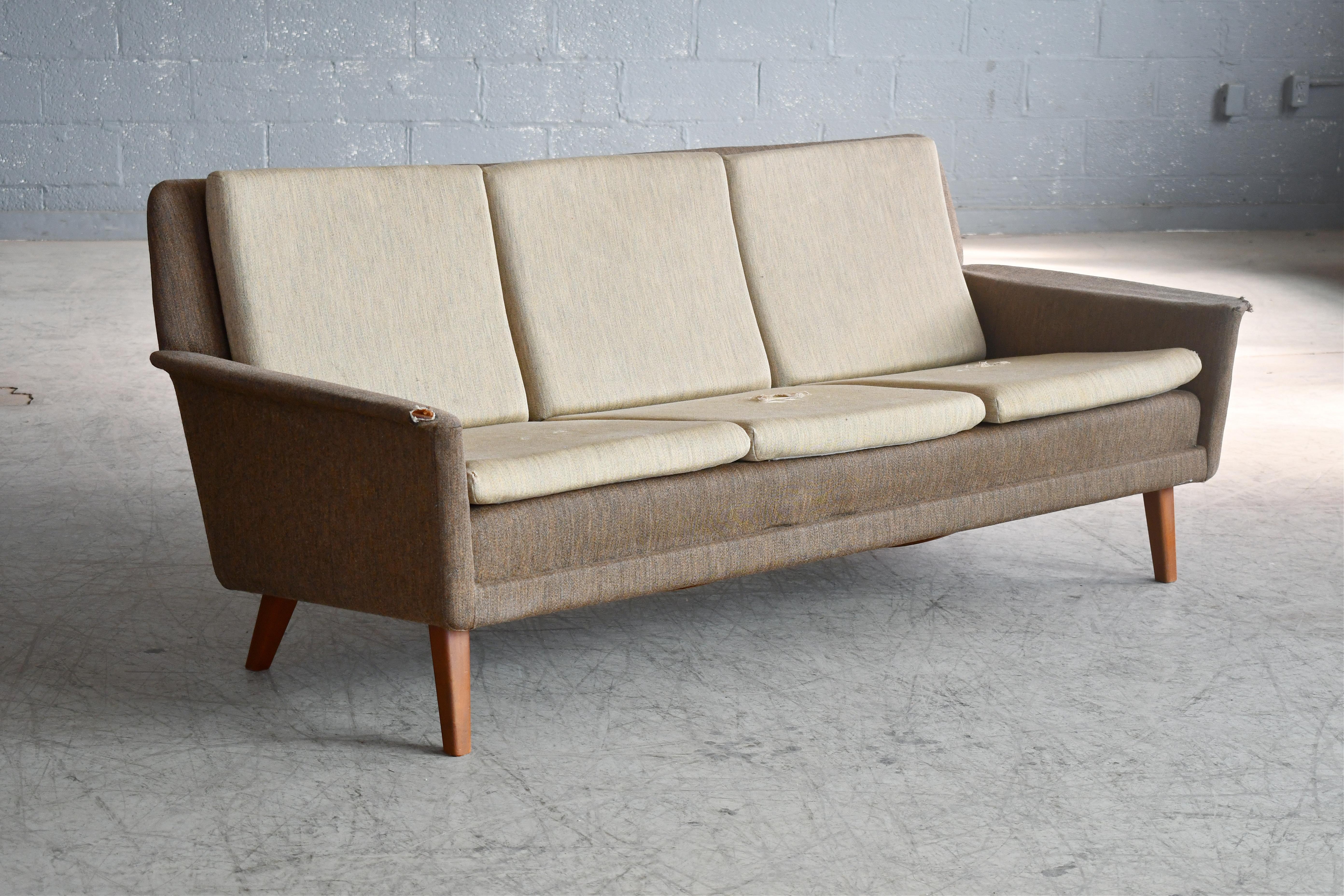 Classic and very elegant three-seat sofa designed by Folke Ohlsson in 1955 as Model 5464 for Fritz Hansen. We love the elegant angles of the sofa and the legs combined the slim cushions raised on teak legs. Very cutting edge in its day and just a