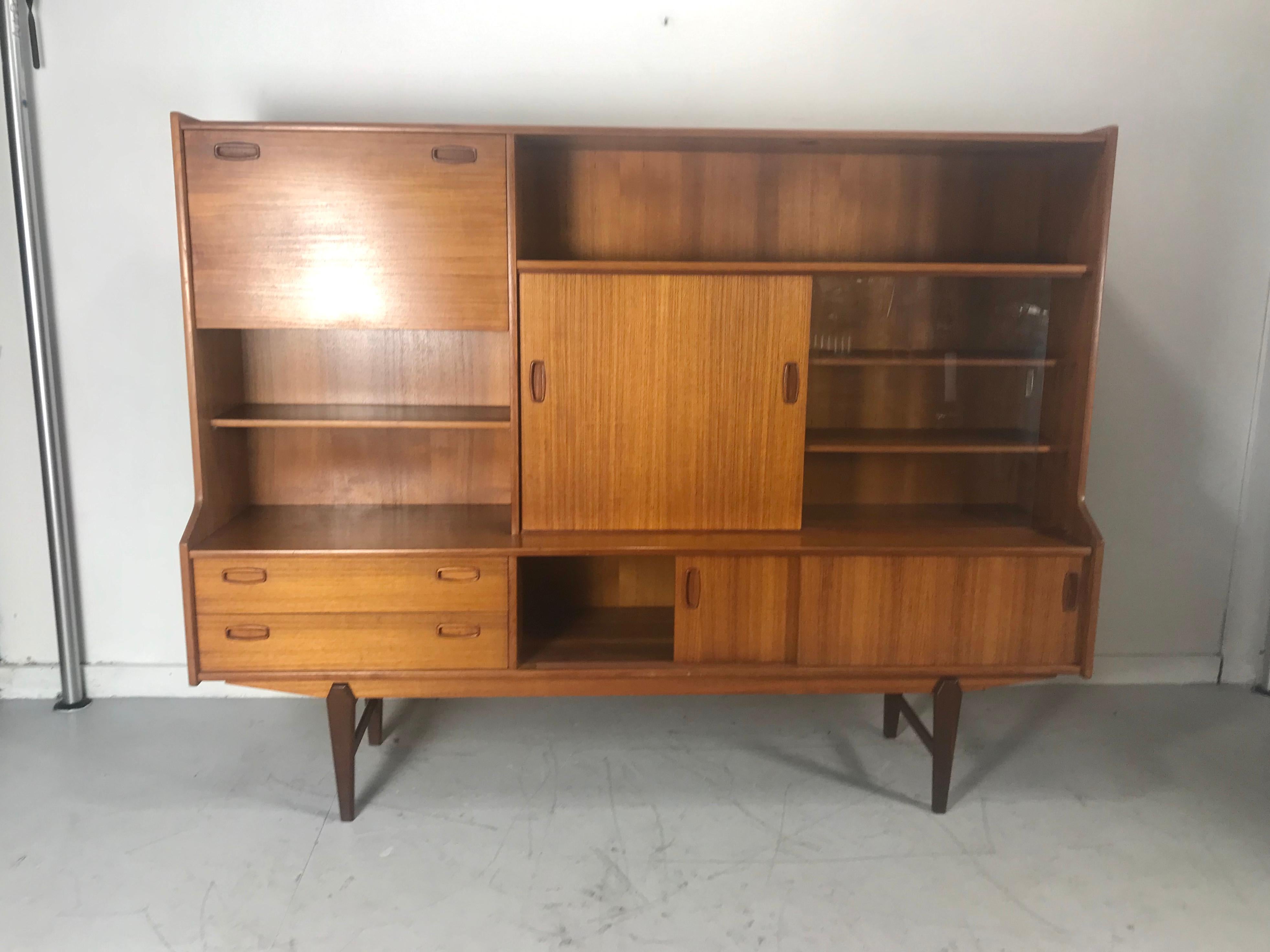 Classic Danish teak cabinet credenza / bar attributed to Omann Jun, perfectly designed. generous storage, sliding doors, wood and glass, drop down bar with light,, silverware drawer, shelves, hand delivery avail to New York City or anywhere en route