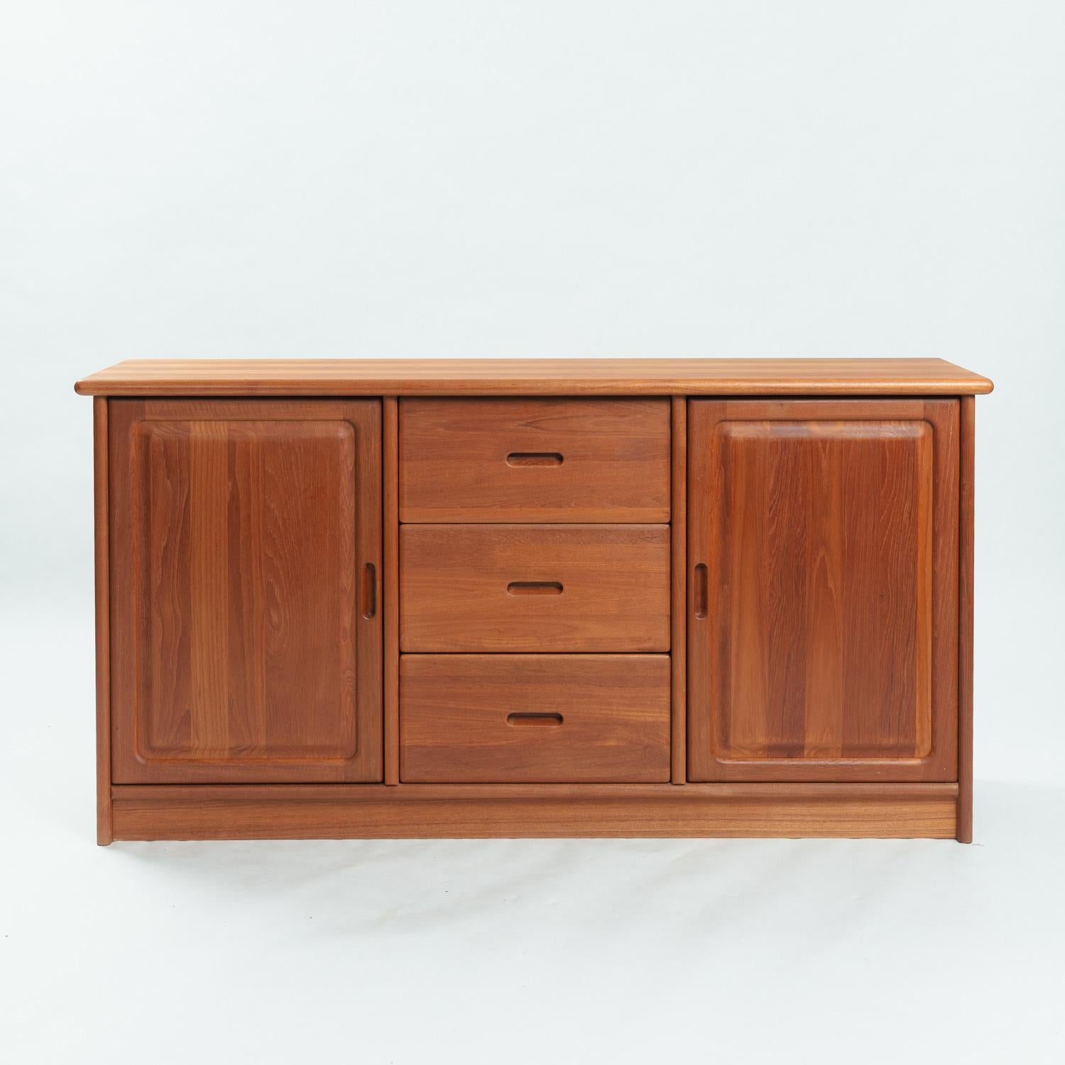 Credenza classica del produttore danese di qualità Dyrlund. 
È contrassegnata dal marchio e timbrata e datata 1990.
Corpo di alta qualità in teak massiccio con due ante, due ripiani e tre cassetti con intarsio. 
In condizioni pari al nuovo.

Misure: