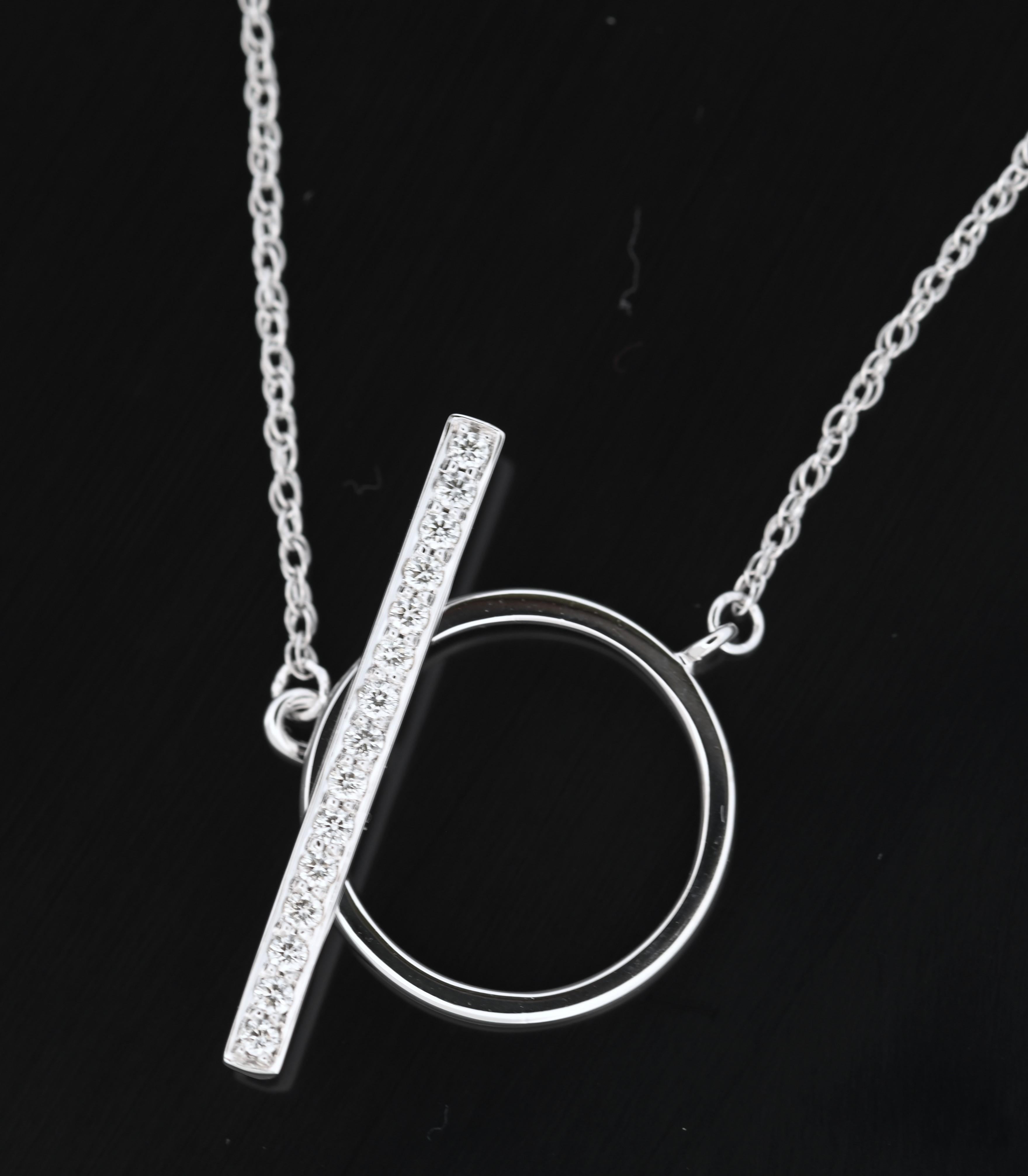 Ti presentiamo una dichiarazione di raffinata eleganza: La collana Bar & Toggle in oro bianco 18 carati. 

Questo splendido pezzo è caratterizzato da un elegante pendente a barra ornato da un'incastonatura di diamanti scintillanti, disposti