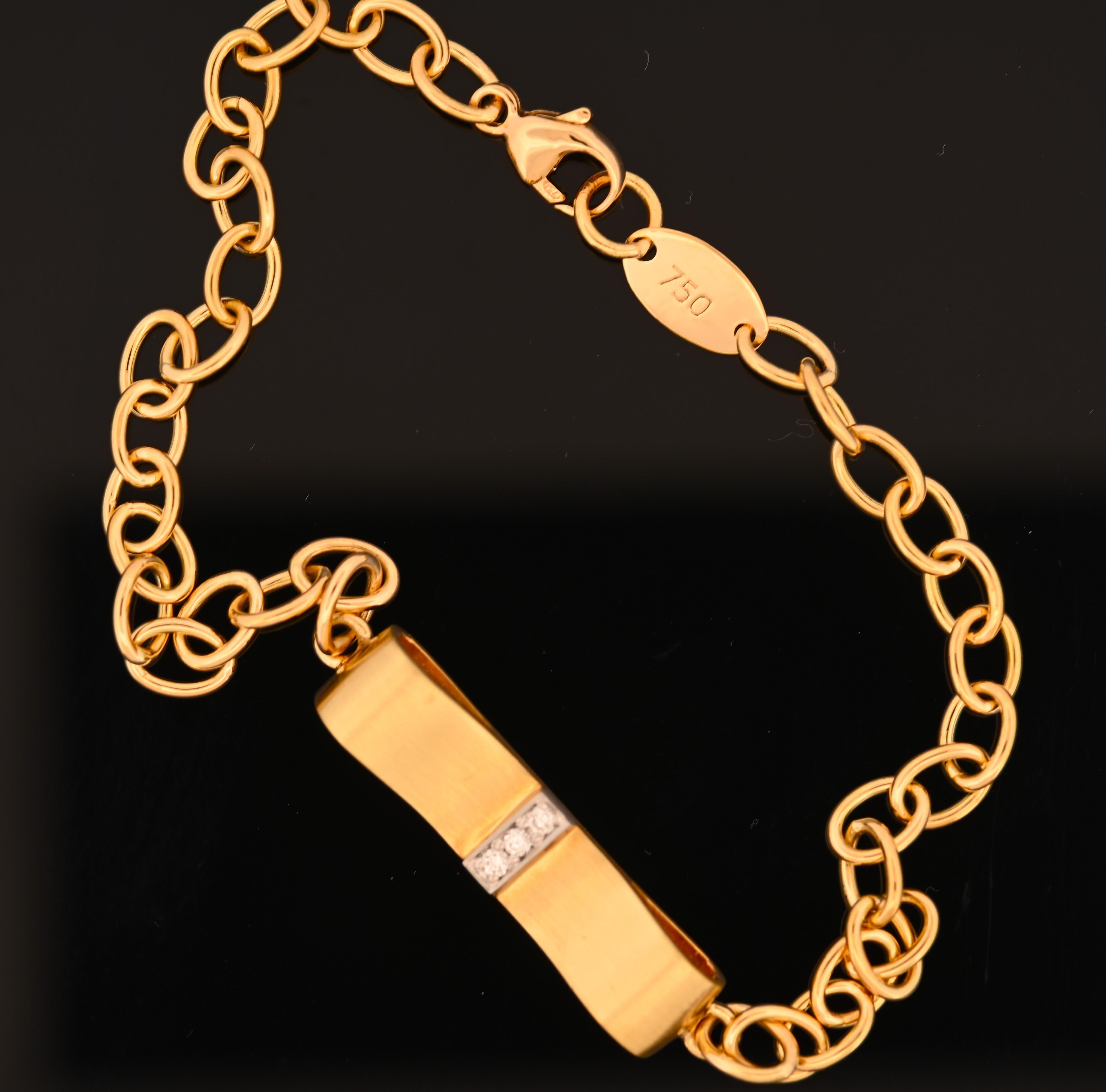 Concediti una raffinatezza senza tempo con questo squisito bracciale in oro 18 carati, magistralmente disegnato con una graziosa forma a nastro. Il bracciale è caratterizzato da un flusso continuo di oro 18 carati lucido e satinato che avvolge