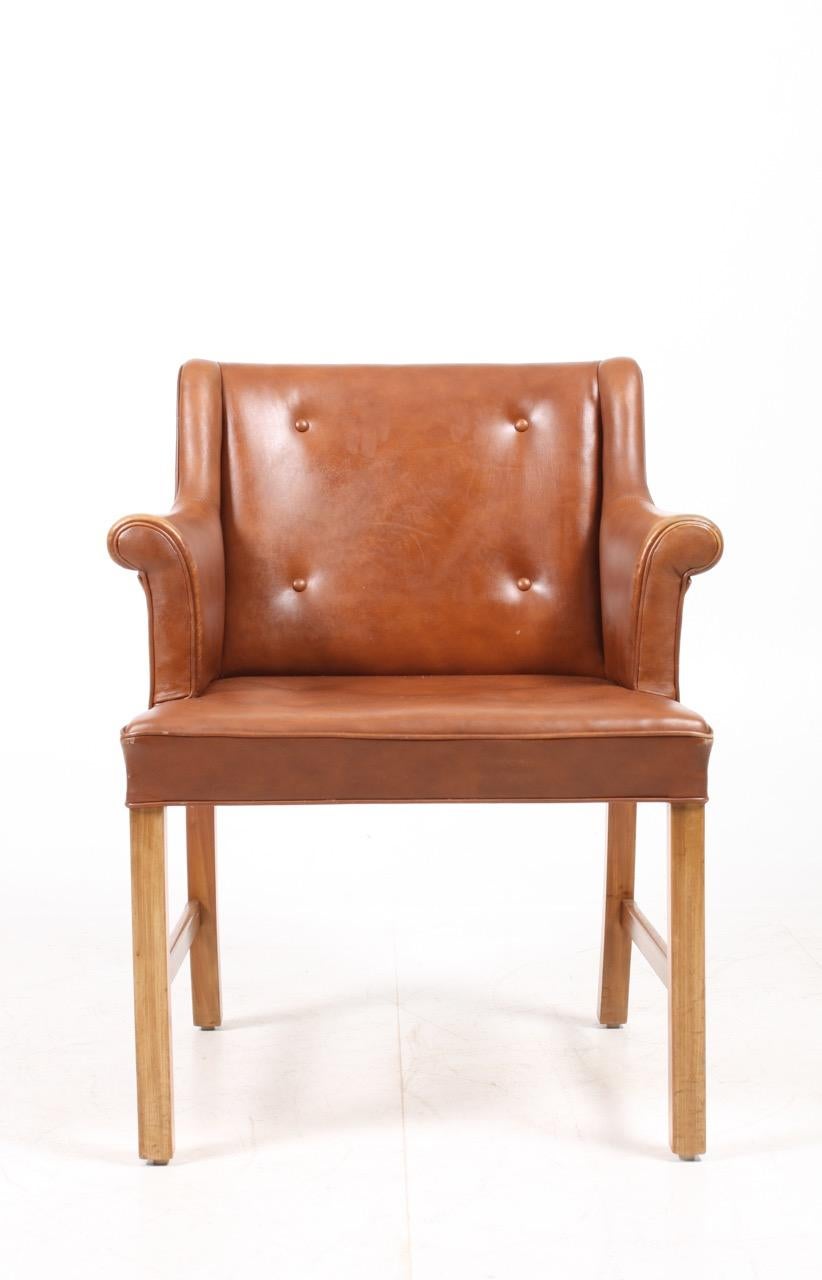Arm chair in patinated leather designed by Ole Wanschar M.A.A. for A.J. Iversen Cabinetmakers in 1950s. Made in Denmark. Great condition.