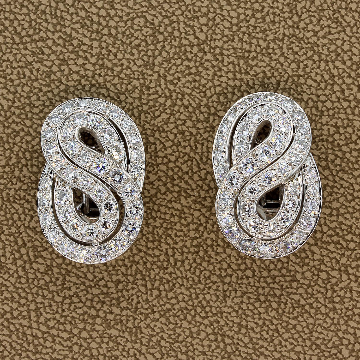 A pair of gold diamond clip earrings. There are 2.78 carats of VVS quality D-E-F color diamonds, the highest of quality. They are set in 18K white gold in an infinity styled design.  Whether it’s the quality you desire, the master craftsmanship or