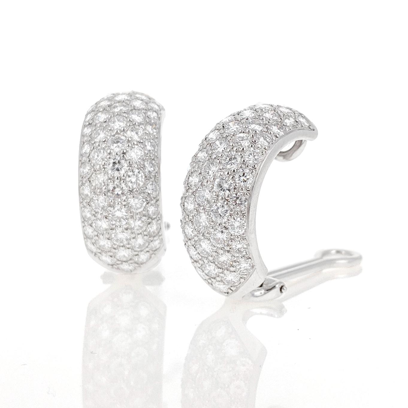 This elegant pair of bombé half hoop clip earrings is pavé-set with approximately 7.0 carats of round shaped diamonds. They are mounted in 18 karat white gold.
