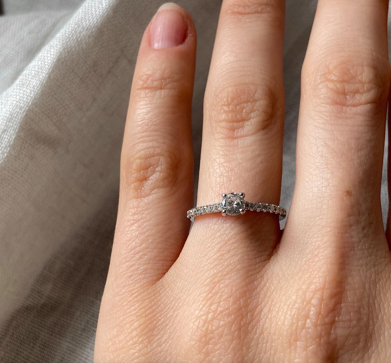 A truly classic solitaire diamond engagement ring, with an approximate 0.30ct brilliant cut diamond centre stone held in a minimal rounded four claw setting. There are eight brilliant cut diamonds in cut-down claw settings cascading down each
