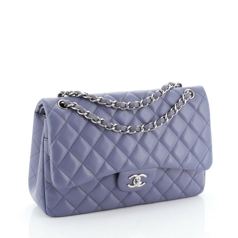 This Chanel Classic Double Flap Bag Quilted Lambskin Jumbo, crafted in purple quilted lambskin leather, features woven-in leather chain link strap, exterior back slip pocket, and silver-tone hardware. Its CC turn-lock closure opens to a purple