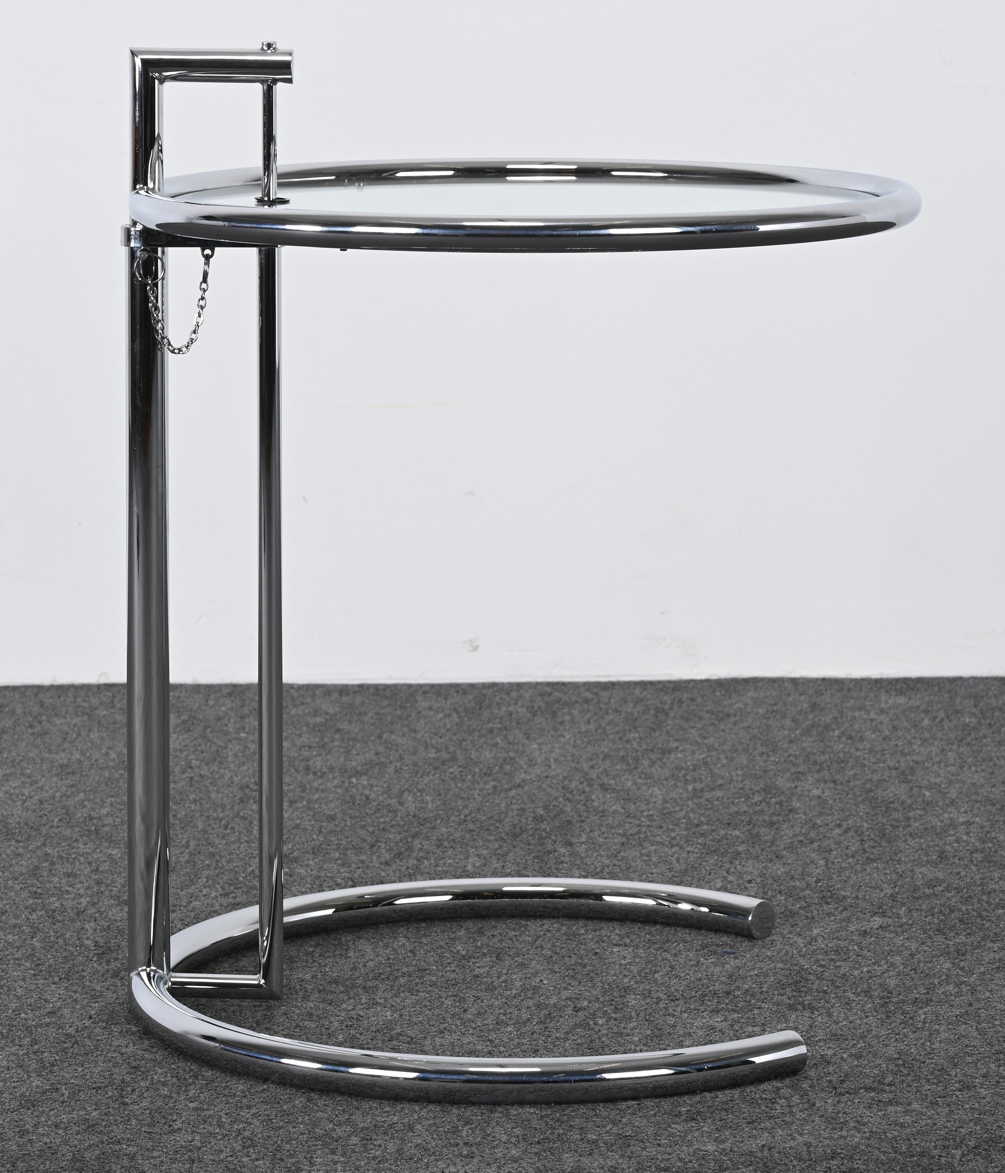 A classic designer E-1027 side table designed in 1927 by Eileen Gray. This adjustable table is one of Gray's most famous designs. The table's adjustable arm and light weight make it flexible and functional. This particular side table was purchased