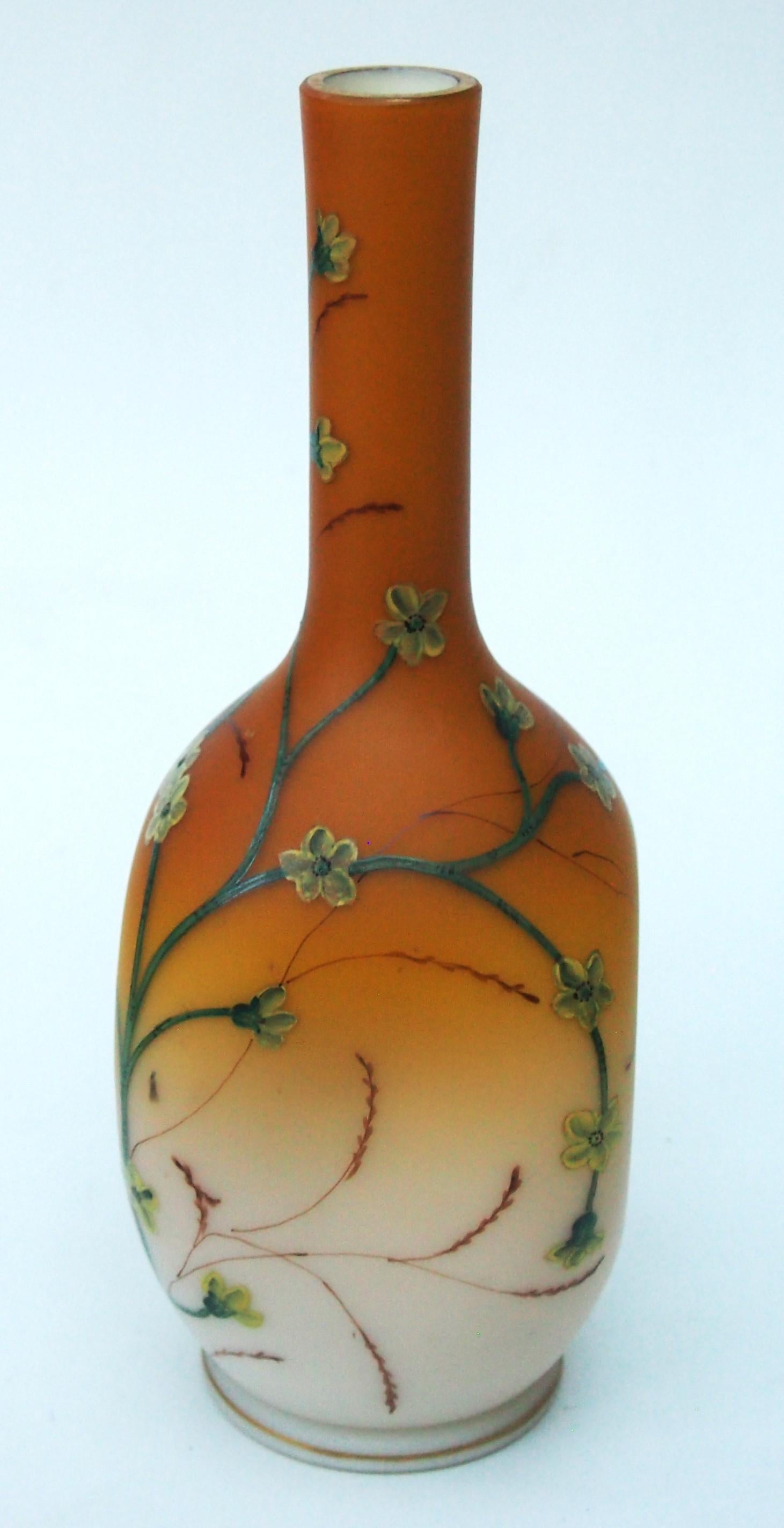 Vase classique en verre de Loetz émaillé de fleurs jaunes et d'herbes vertes sur fond pêche en haut et blanc en bas, fabriqué vers 1890. Un vase à haut col  d'abord soufflé circulairement puis, encore chaud, pincé pour donner un profil presque carré