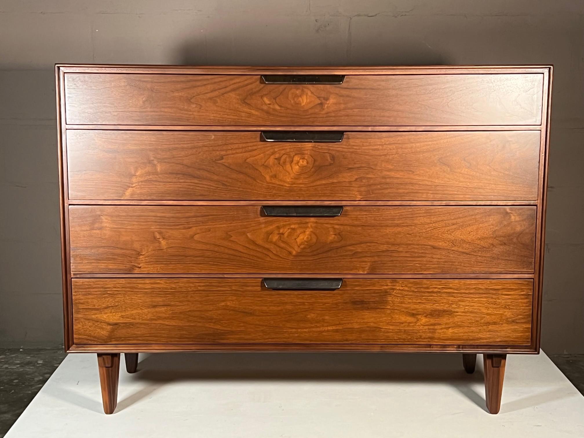 Stunning walnut Dunbar chest designed by Edward Wormley. Four large scale drawers. Legs feature Japanese style- studio/ craftsman details. Leather wrapped handles (dark brown) show some signs of wear. Dresser has been completely restored. Medium