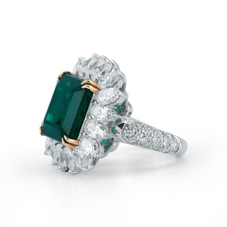 CLASSIC EMERALD AND DIAMOND RING A classic diamond styling featuring oval diamond halo and an exquisite square emerald cut emerald. Item: # 01684 Metal: 18k W / Y Lab: Gia Color Weight: 10.96 ct. Diamond Weight: 7.03 ct.
