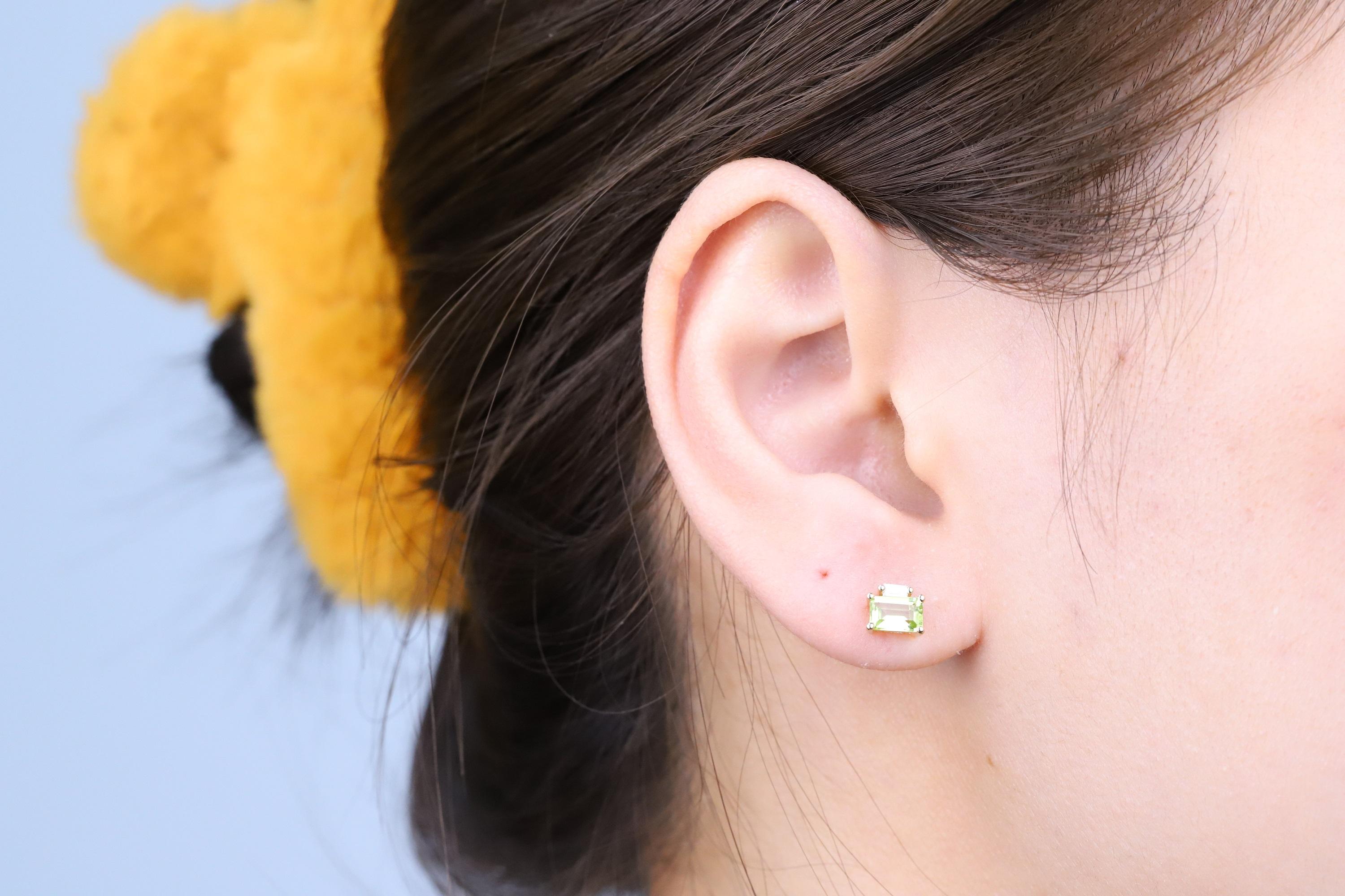Décorez-vous d'élégance avec cette boucle d'oreille réalisée en or jaune 10 carats par Gin and Grace. Cette boucle d'oreille est composée de péridots 6x4 taille émeraude (2 pièces) de 1,23 carat et de diamants blancs taille baguette (2 pièces) de