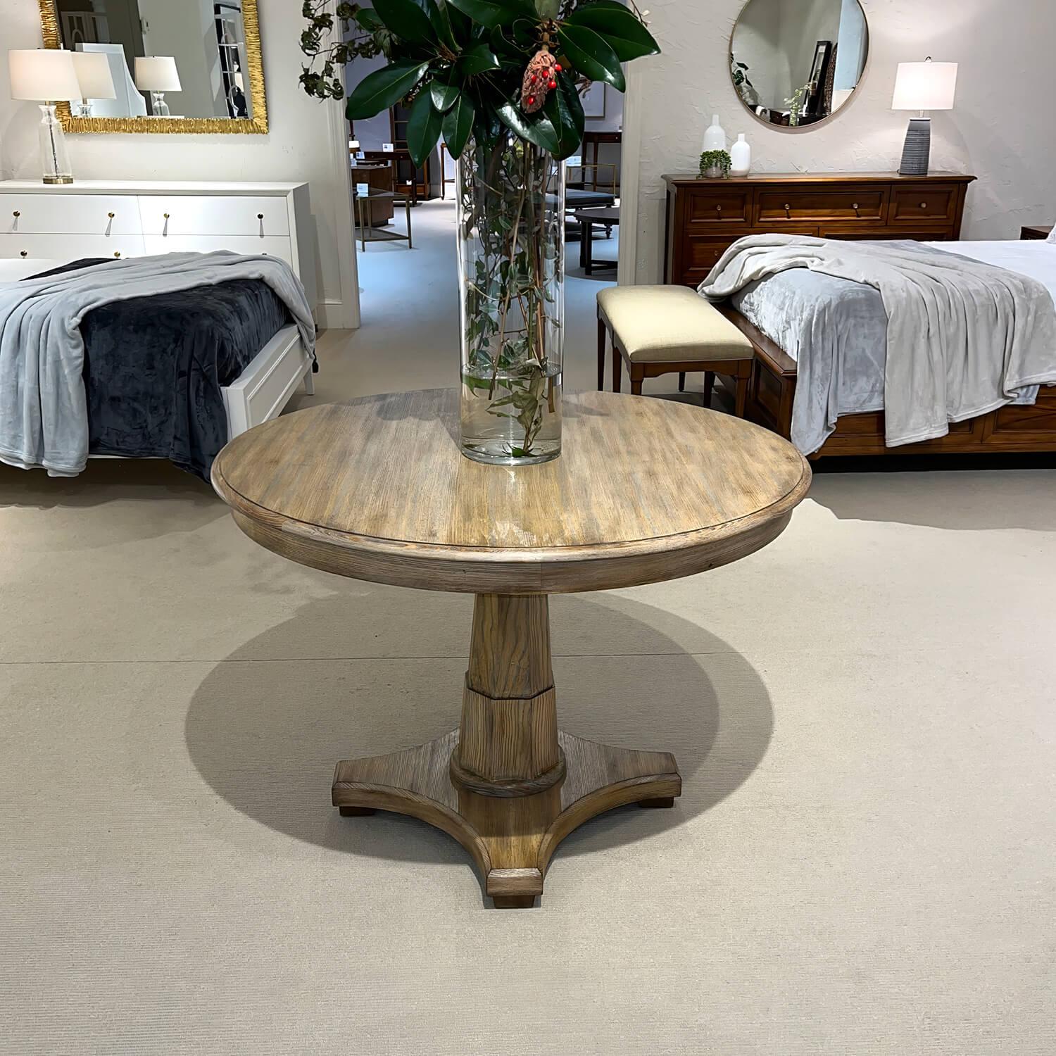 A Classic Empire style grey cerused oak oatmeal stained center table with a carved ogee edge, raised on an octagonal pedestal base. 

Dimensions: 42