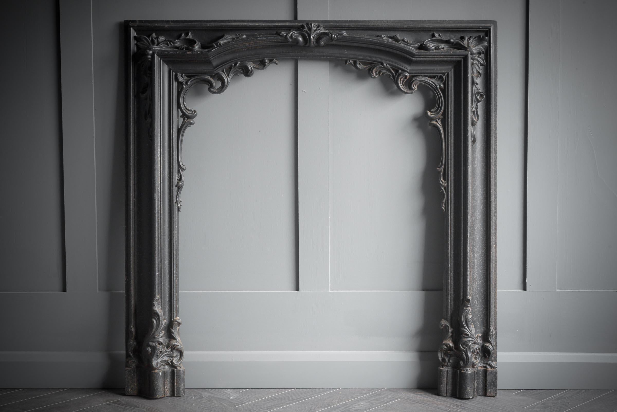Antique reclaimed Edwardian Art nouveau cast iron fire surround, with floral detailing at the top of the arch. The matt black finish is original and would add an elegant focus to any fireplace.