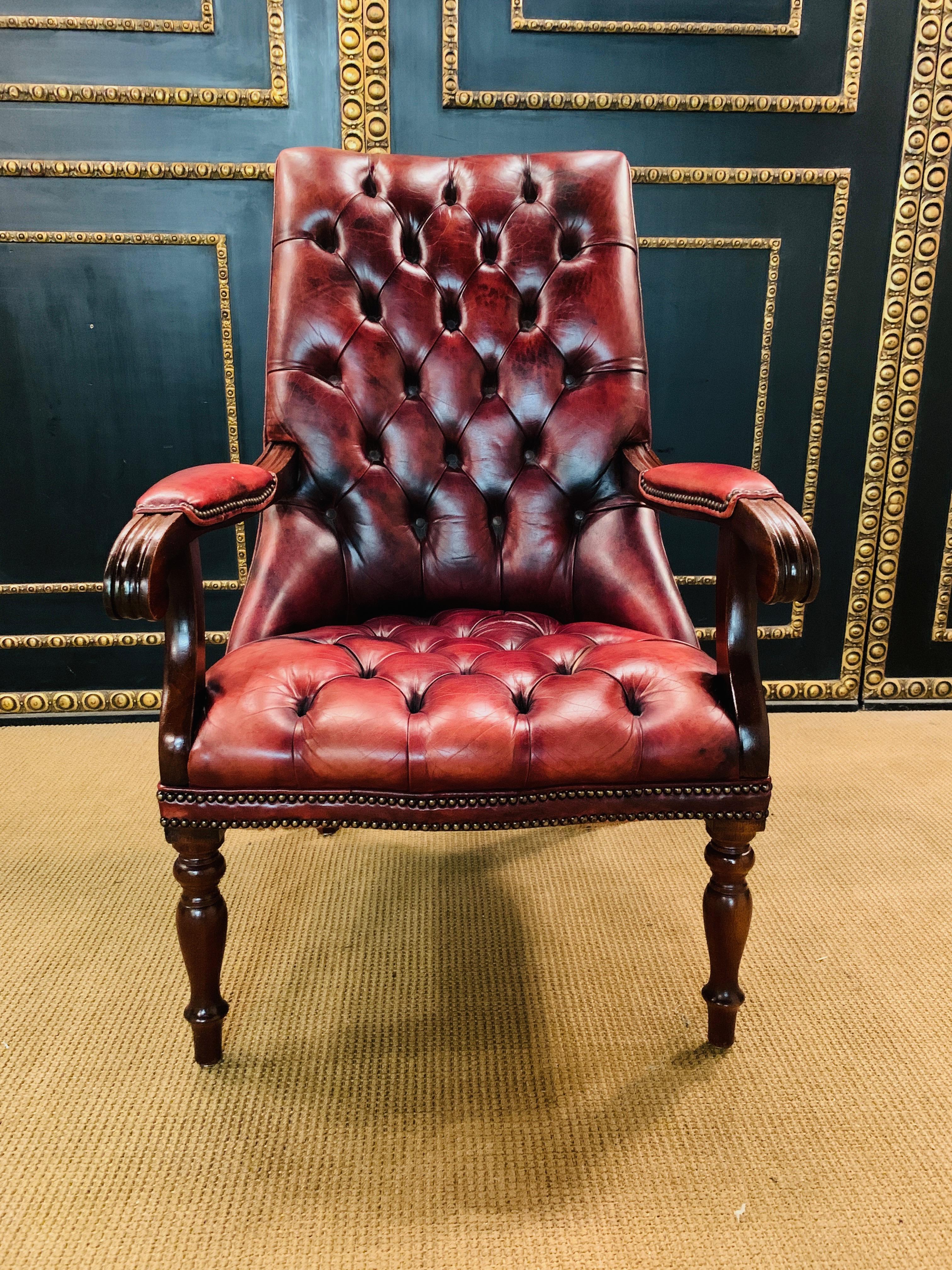 Classic English Chesterfield armchair, oxblood or Bordeaux leather complete upholstery in Chesterfield. Classic shape and extremely comfortable, 20th century. Solid mahogany wood.