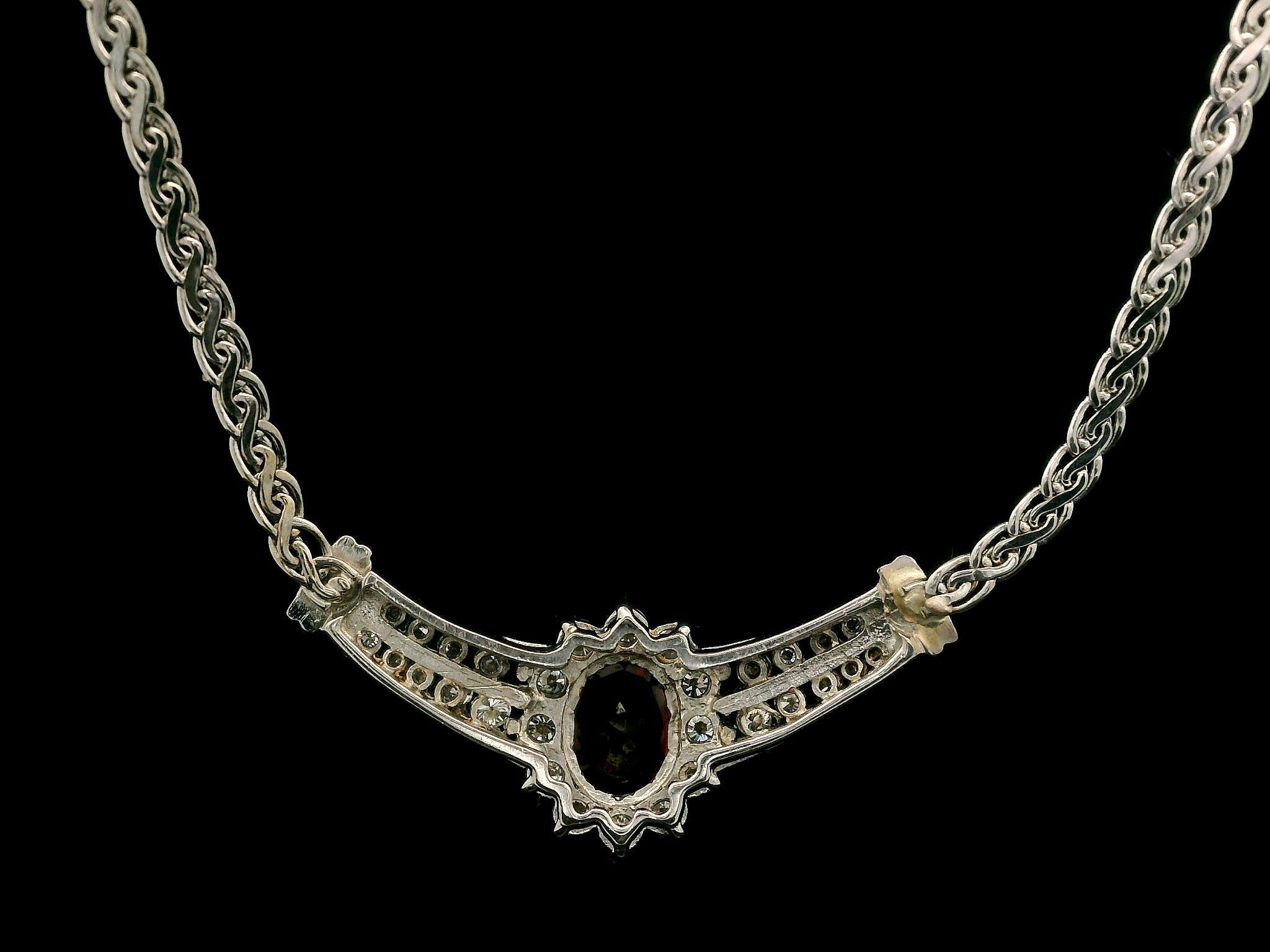 -A. Stone
(1) Granato naturale autentico - taglio ovale - incastonato - 8x6mm (circa) - 1,40ctw (circa)
(30) Diamanti Nature autentici - Taglio tondo brillante - Incastonatura a griffe e a canale - Colore G/H - Purezza SI1-I1 - 0,60ctw