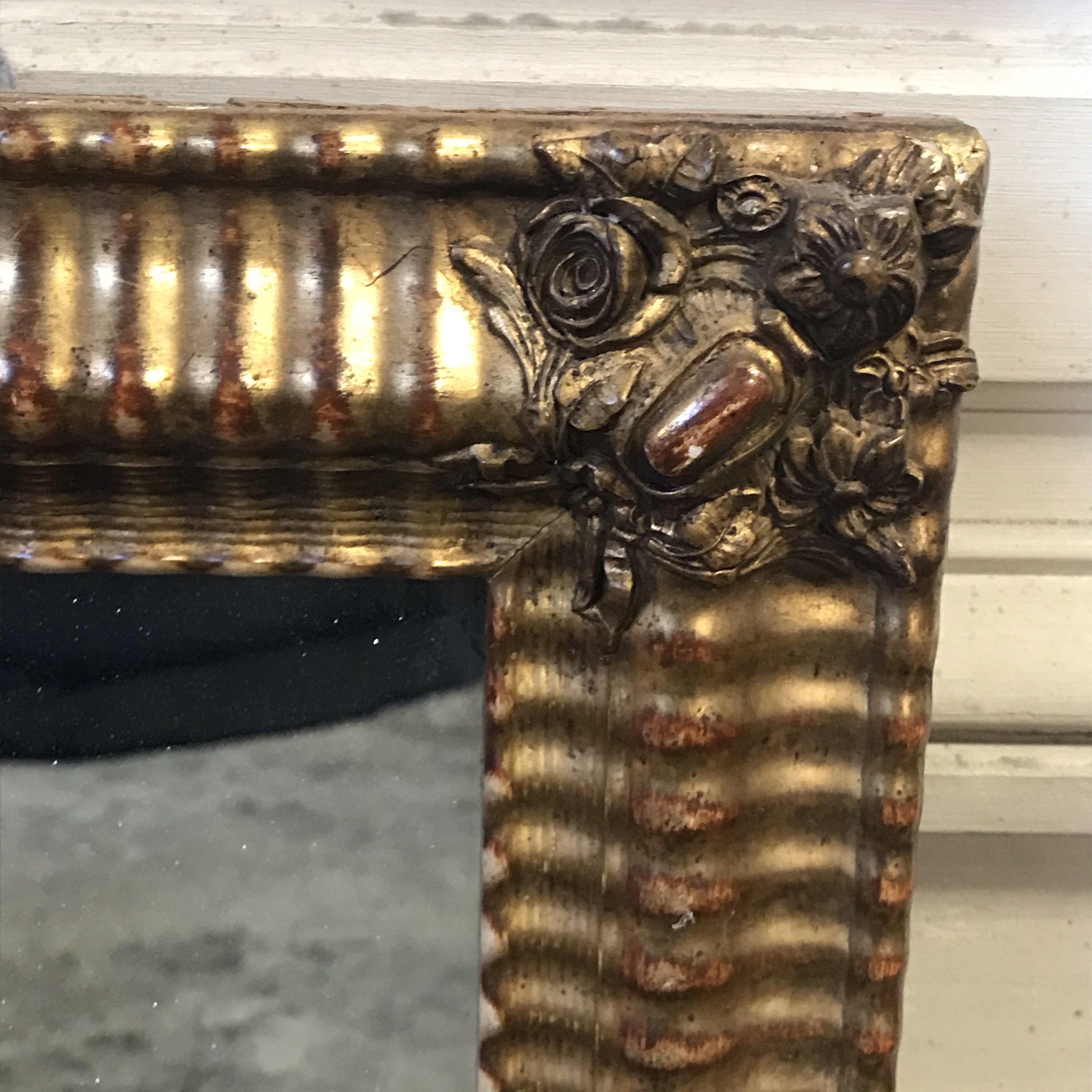 Antique French water gilded mirror with gorgeous original frame. Great aged patina, in some areas where the gold has worn thin there are beautiful subtle tones of the red undercoat showing through the gold.

#3576.