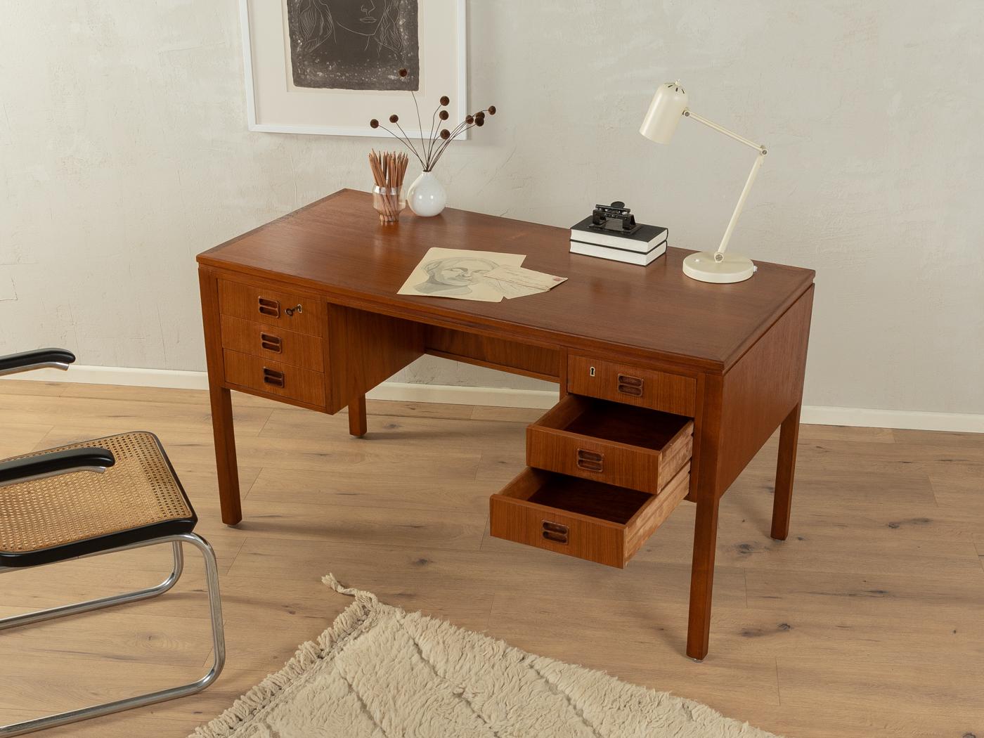 Klassischer freistehender Schreibtisch aus den 1960er Jahren von Tibergaard. Hochwertiger Korpus in Teakholzfurnier mit sechs Schubladen, einem Bücherregal auf der Rückseite und Massivholzbeinen.
Tischunterkante 70 cm

Qualitätsmerkmale:
   