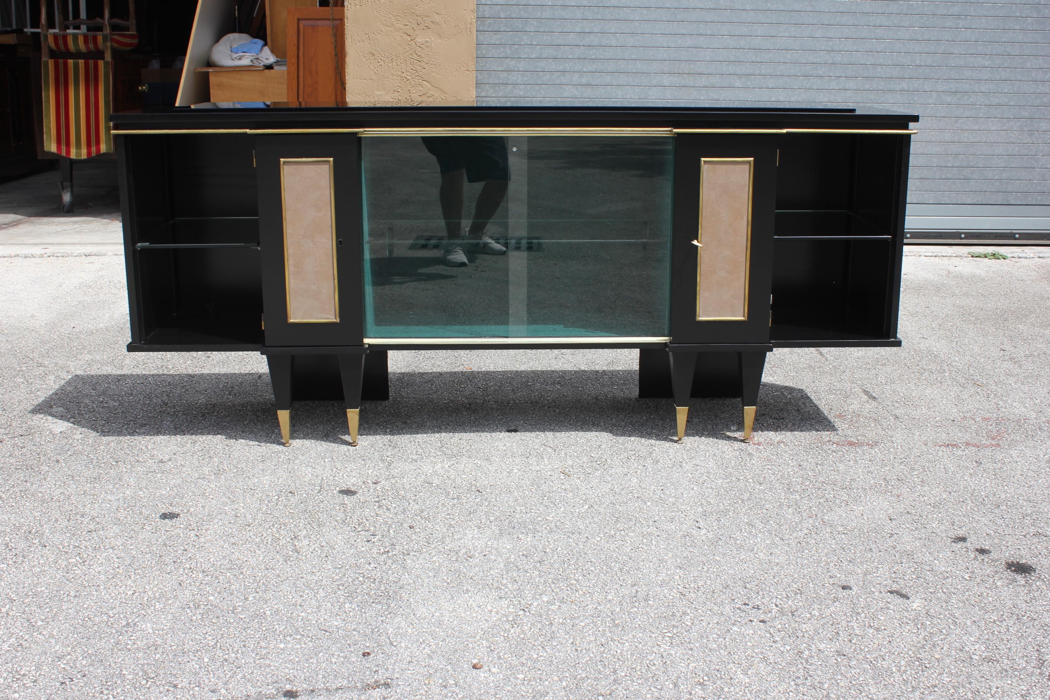 Classic French sideboard or bar or buffet made of mahogany with a black glass top , the mahogany wood has been ebonized and finished with a French polished high luster. The sideboard have two doors with leather face ,and two sliding glass doors with
