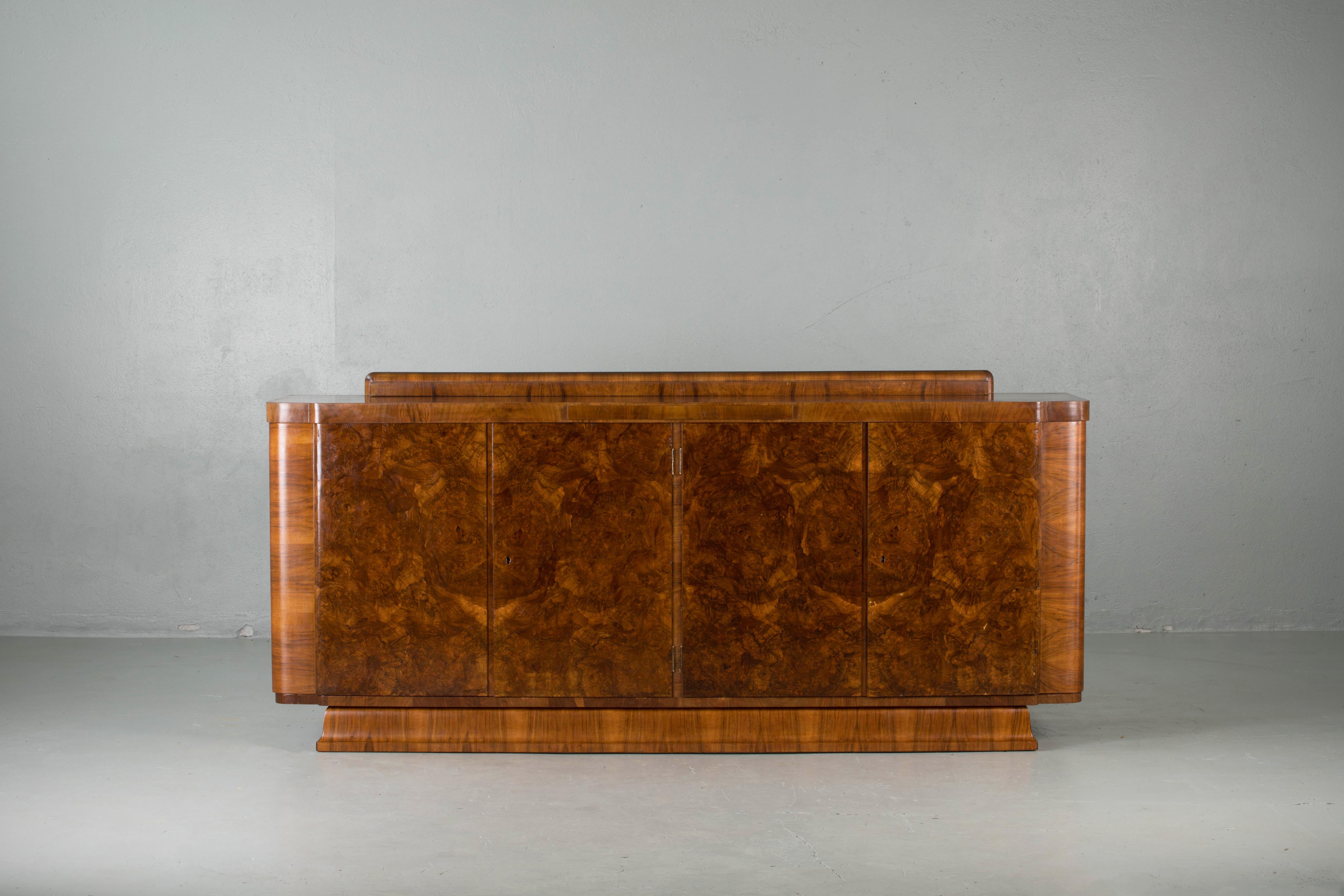 French Art Deco Classic burr walnut sideboard or buffet, circa 1930s.
This luxurious piece was originally made in Strasbourg (France) in the 1930s.
The sideboard features five inside drawers, a marble tablet and two shelves.
The curved lines of this
