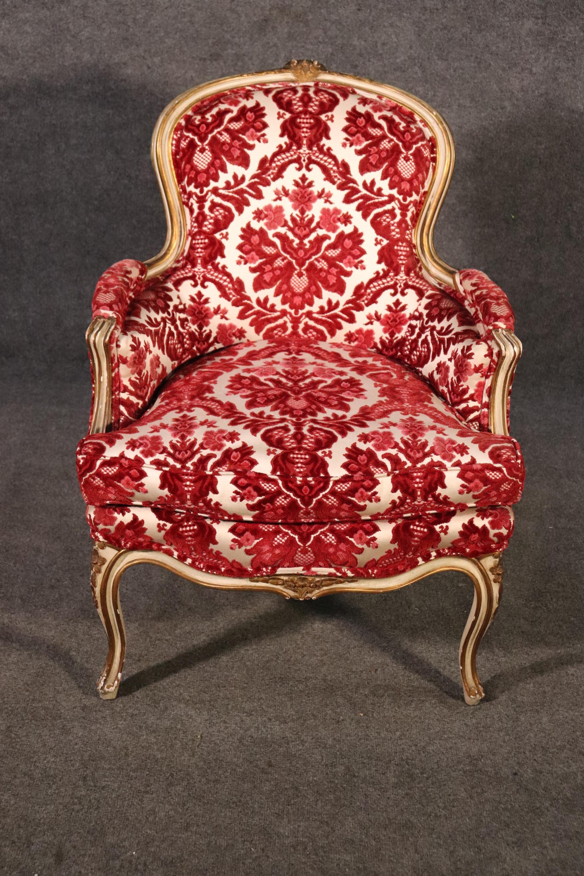 This is a beautiful classic French Louis XV style bergere chair. The chair features a gorgeous original painted frame and its original floral velvet upholstery. The chair measures 36 tall x 26 wide x 26 deep and the seat height is 19 inches. The