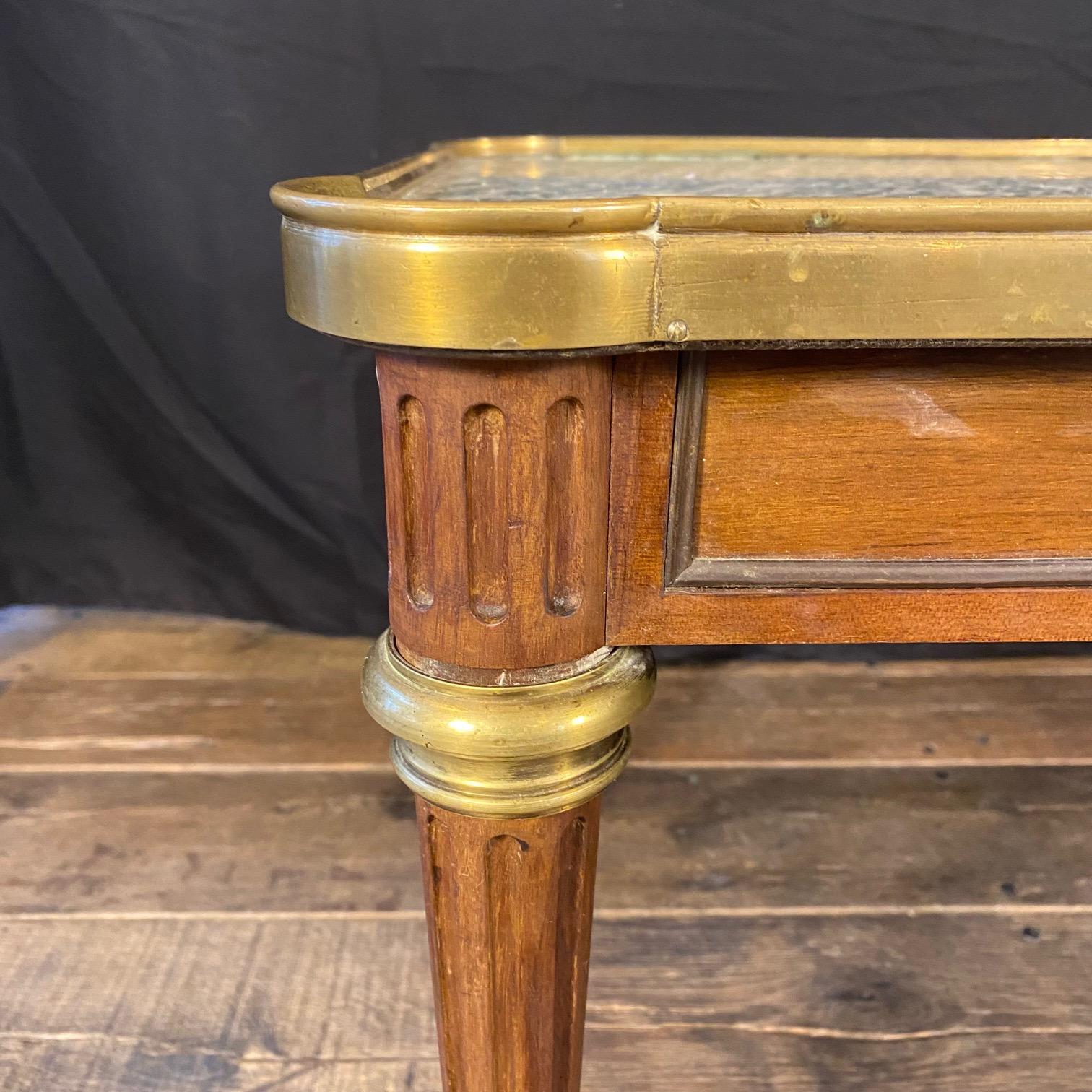 Elegante table basse française classique à plateau de marbre monté en bronze doré, de style Louis XVI, avec bordure en laiton, provenant de Paris, France. Cette fabuleuse table basse est un très bel exemple de l'ébénisterie parisienne Mercier Frères