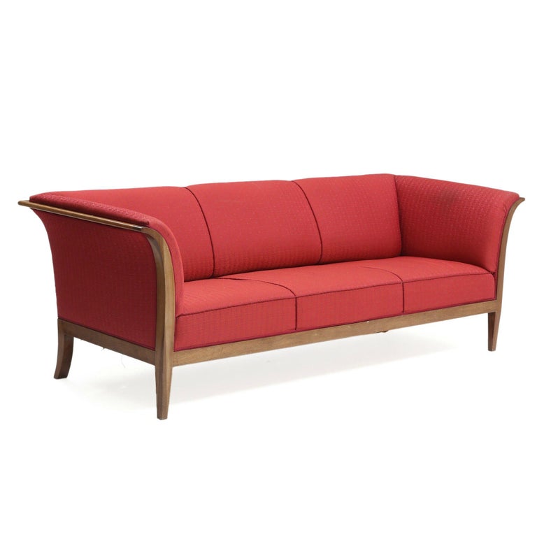 This elegant and generously sized three-seat sofa was designed and made by the Danish master cabinetmaker, Frits Henningsen in the 1930s and most likely produced between 1937-1942. The Cuban mahogany frame extends from flared armrests and into a