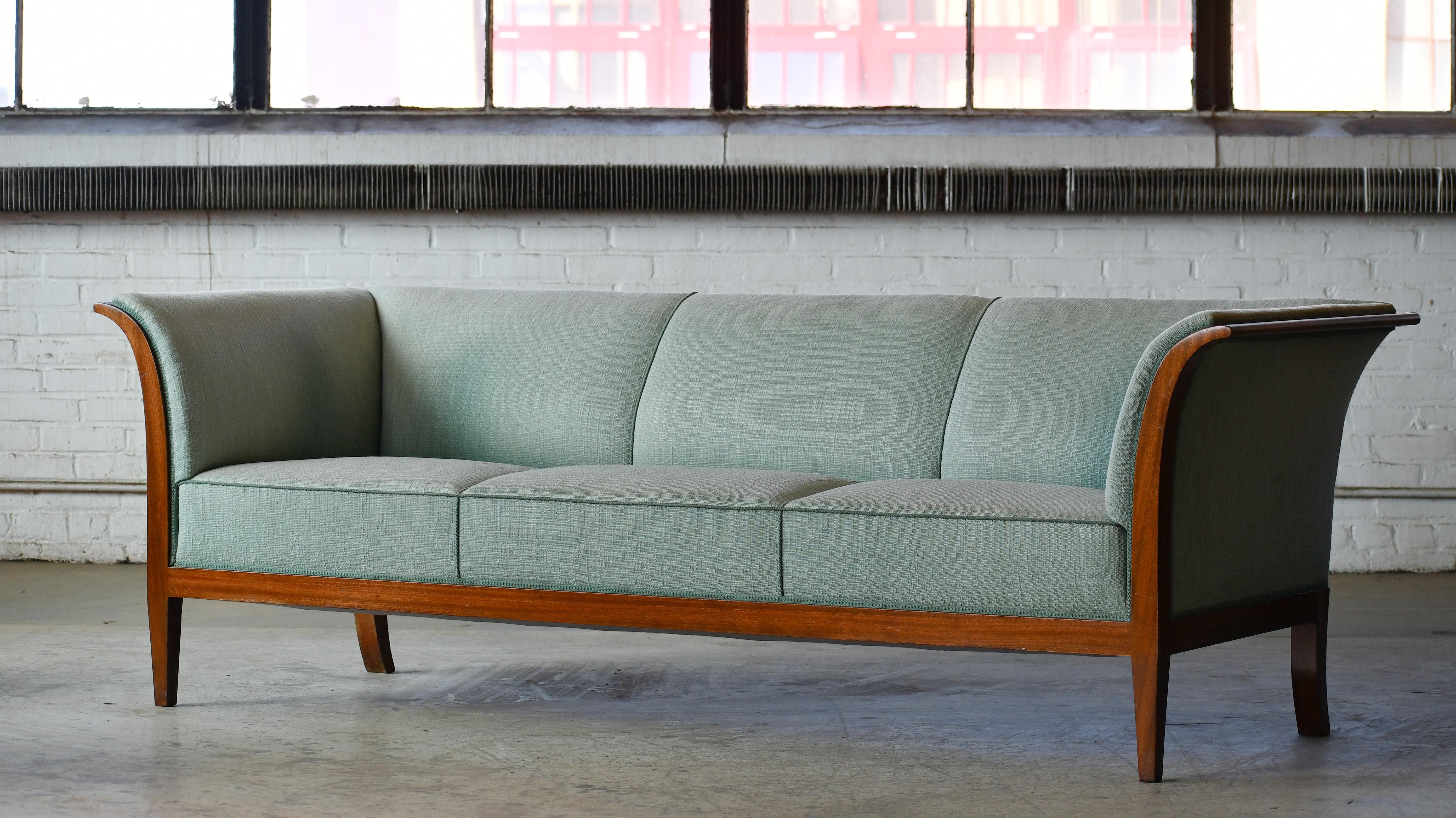 This elegant and generously sized three-seat sofa was designed and made by the Danish Master Cabinetmaker, Frits Henningsen in various size up through the 1930s till about 1950. This very fine and sizeable specimen was most likely produced between