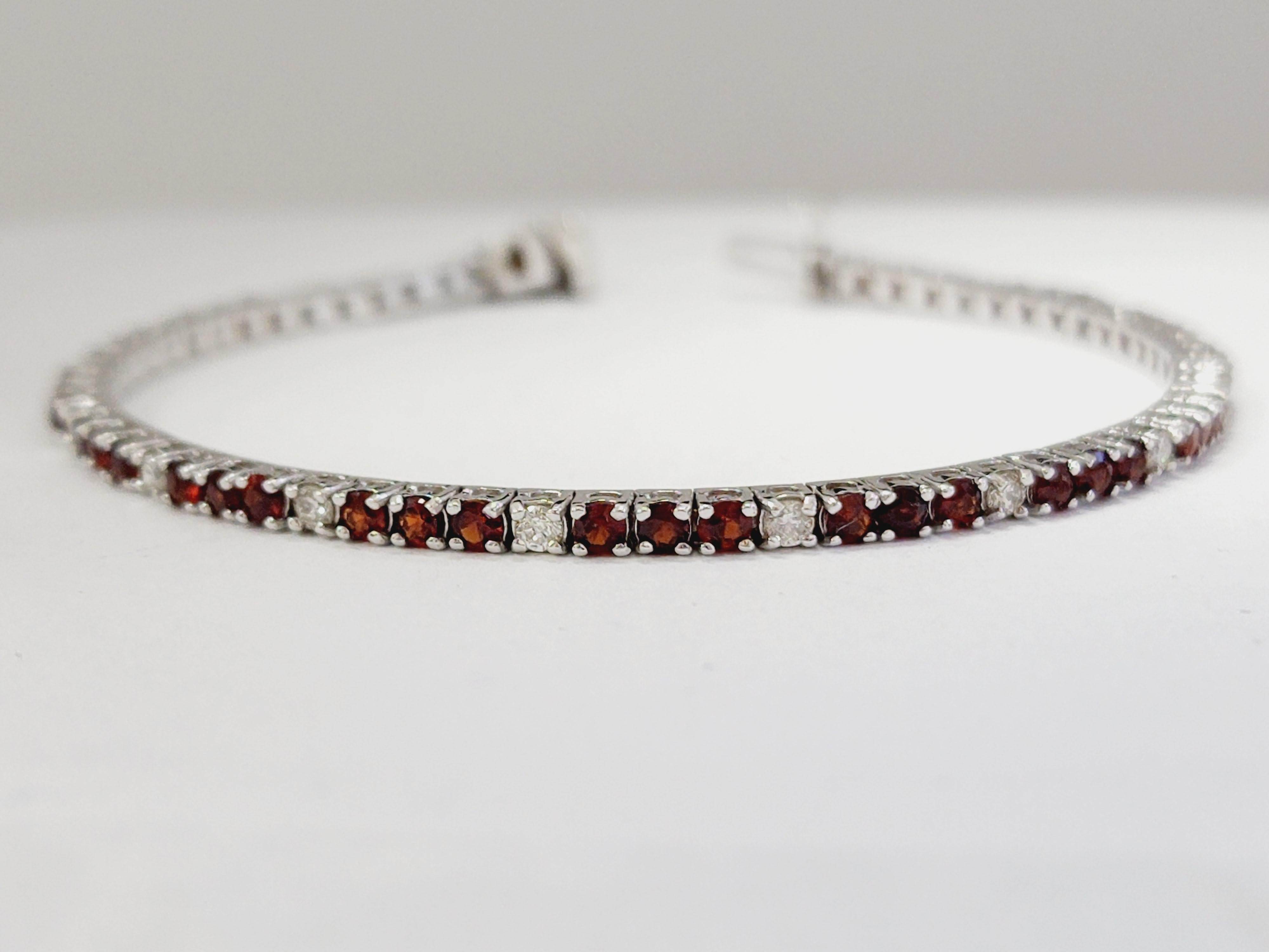 Crafted in white gold 14k, this garnet tennis bracelet is a classic beauty. The 4 prong set round garnets allure with their striking intense red hue. This garnet eternity bracelet secures with a insert clasp.

Garnets 3.30 ct , 
Diamonds 0.70 ct