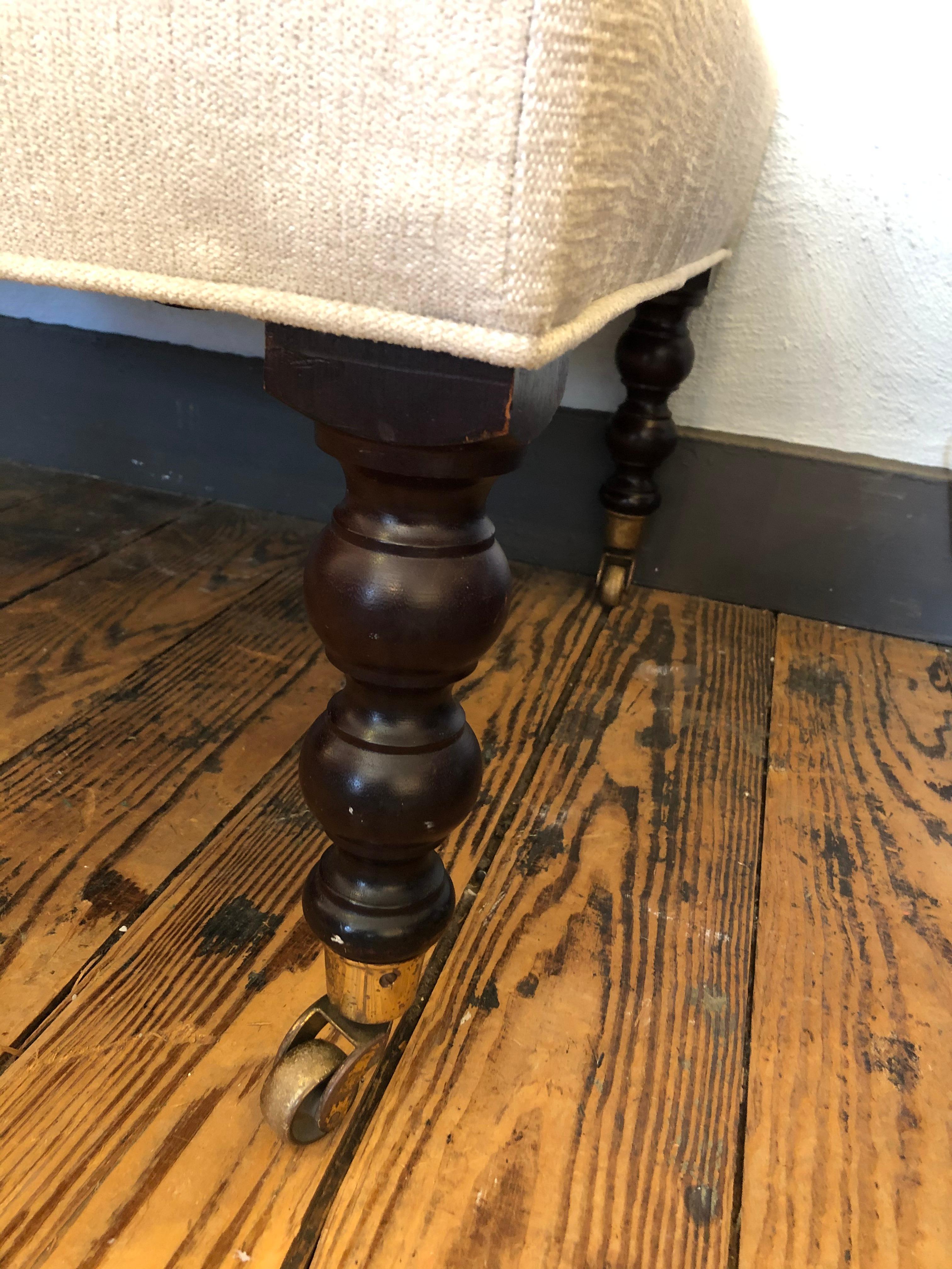 Classic rectangular George Smith style ottoman newly upholstered in neutral plush beige chenille and having turned mahogany legs on brass casters. Perfect size for use as a coffee table.