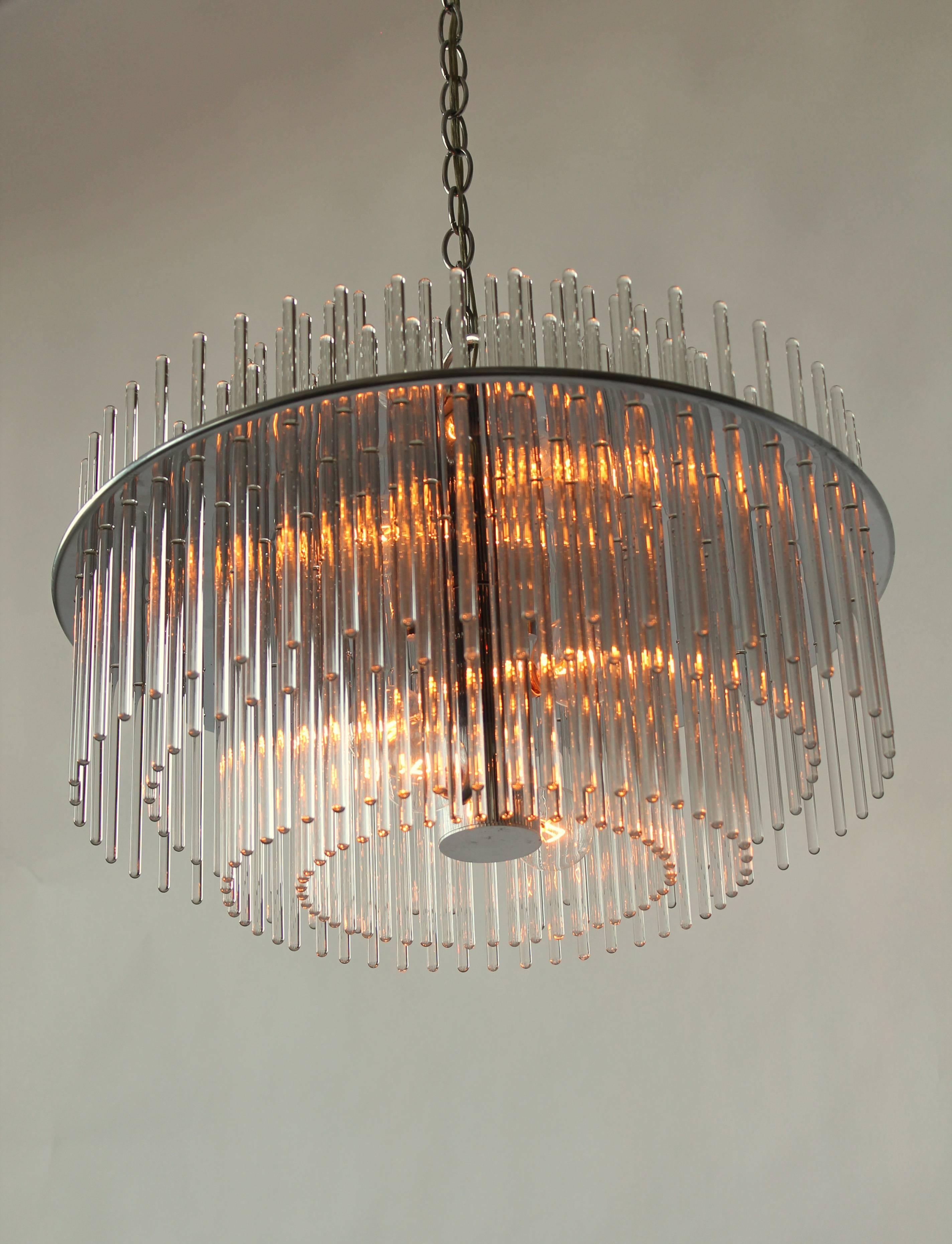 Classic 1980s Lightolier chandelier from their Radiance line.

Four row of light catching optical quality glass rods sitting on a nickel plated pierced steel-plate.

Well made solid construction . 

6 E12 candelabra size socket rated at 40