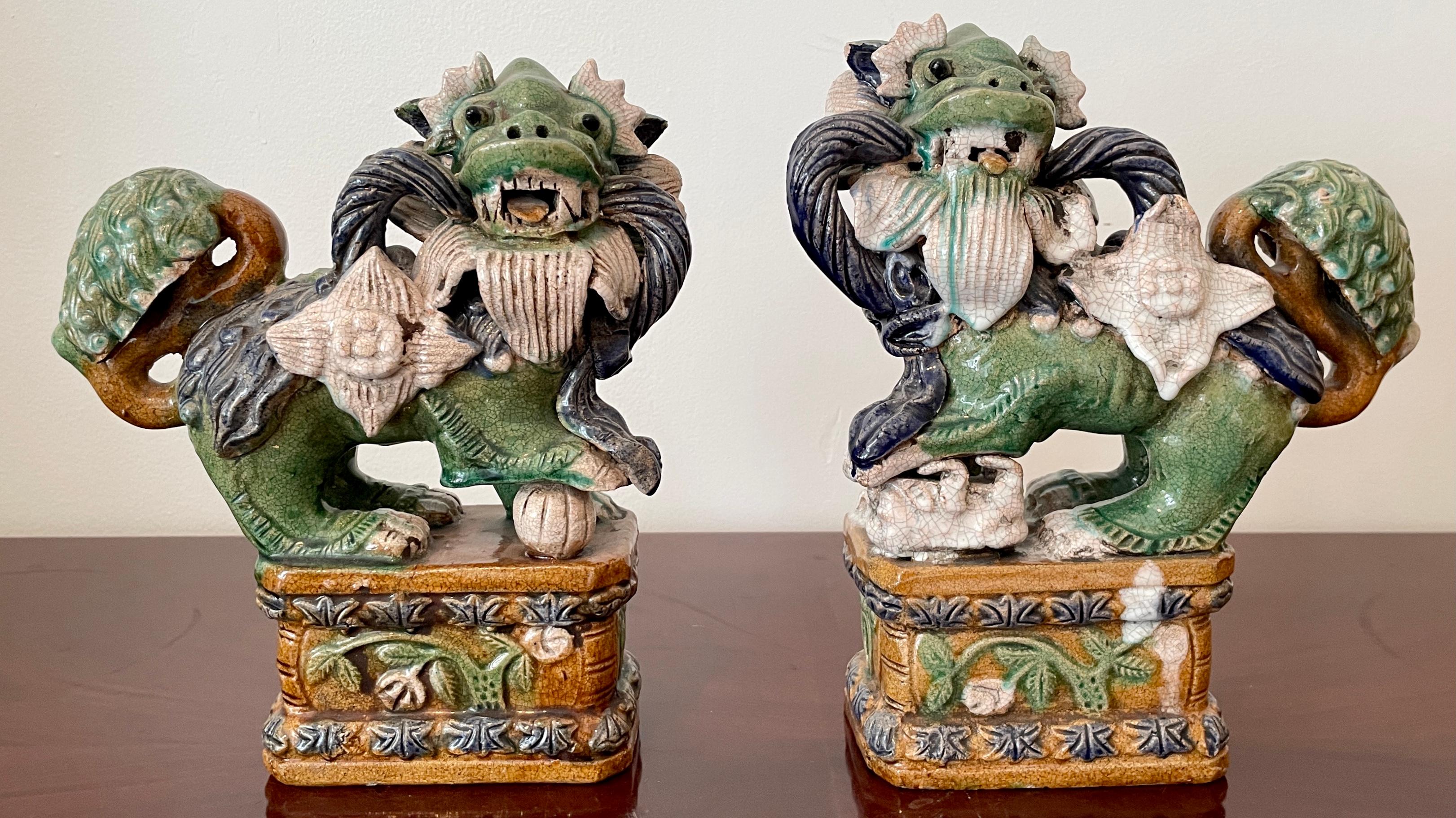 Gorgeous pair of glazed terra cotta male and female Foo Dogs standing on a base. Great addition to your Asian and classic inspired interior table tops.