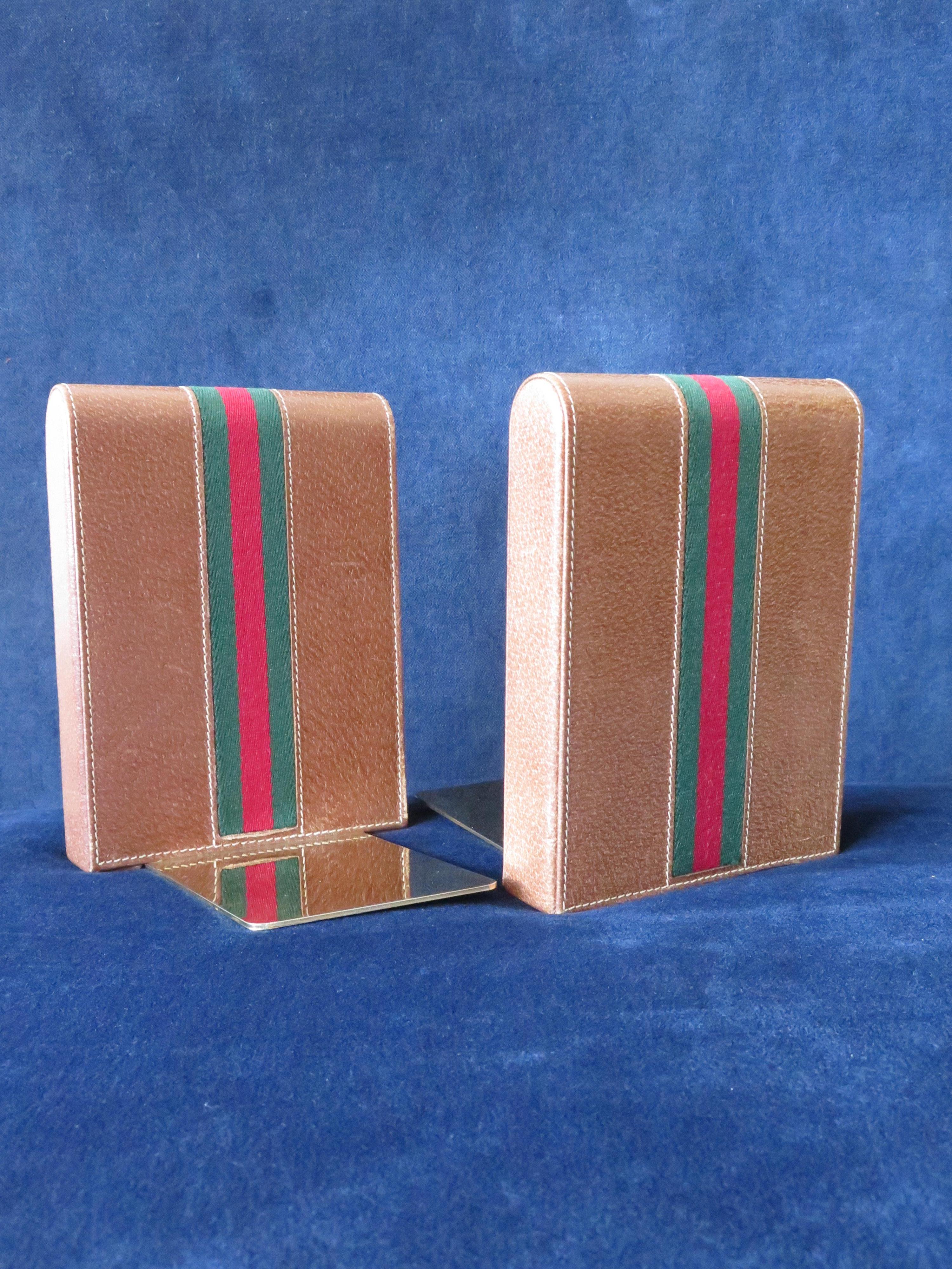 A pair of classic bookends by Gucci. Classic brown leather stripe with brass bases. Beautiful stitching and attention to details.