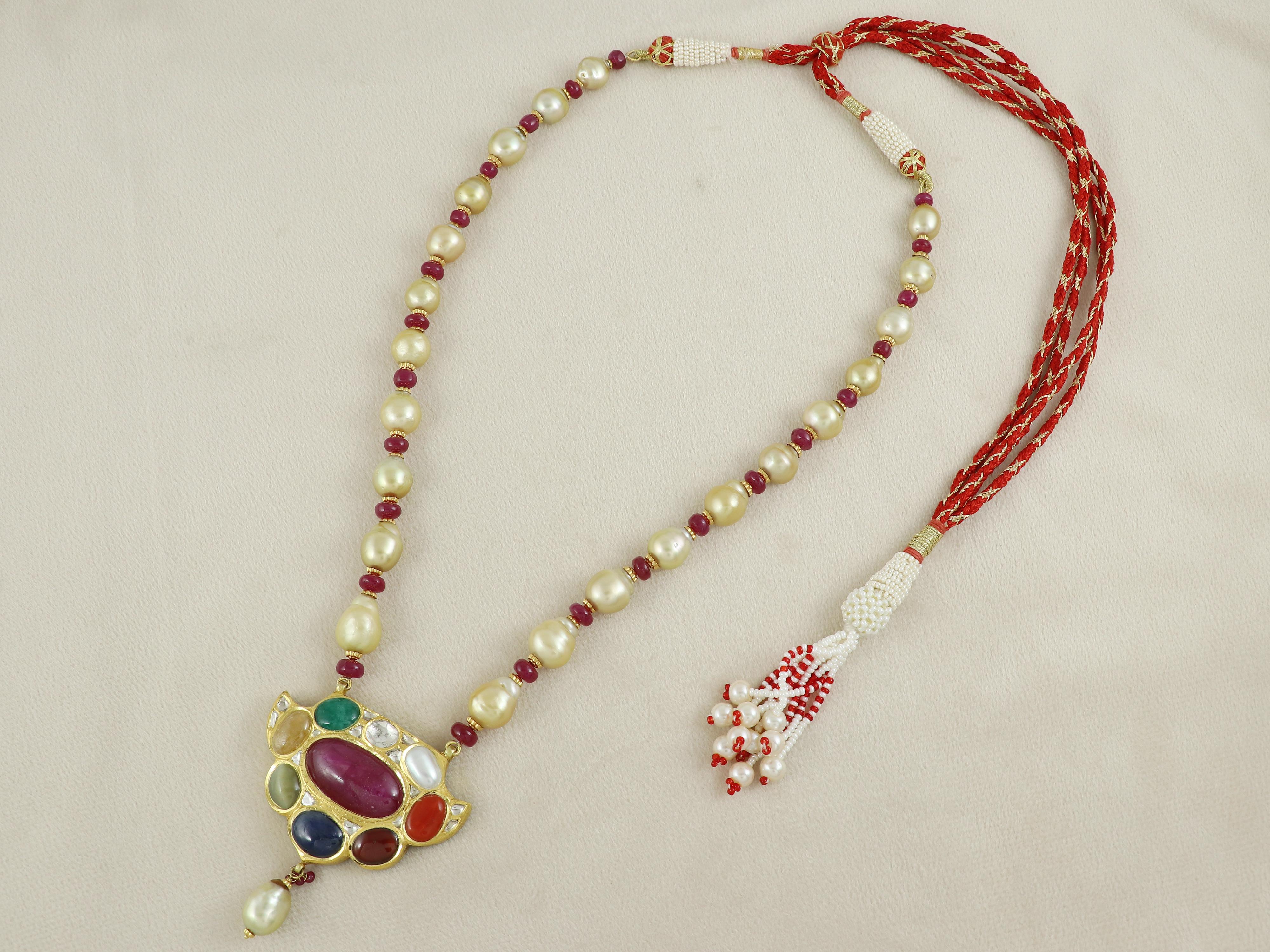 Coming from the age old tradition of Kundan Meena polki fine jewellery, this navratne pendant has been made in 18K gold and has been finely enamelled at the back in red and green floral motifs enhancing the beauty of the pendant. 

The pendant has