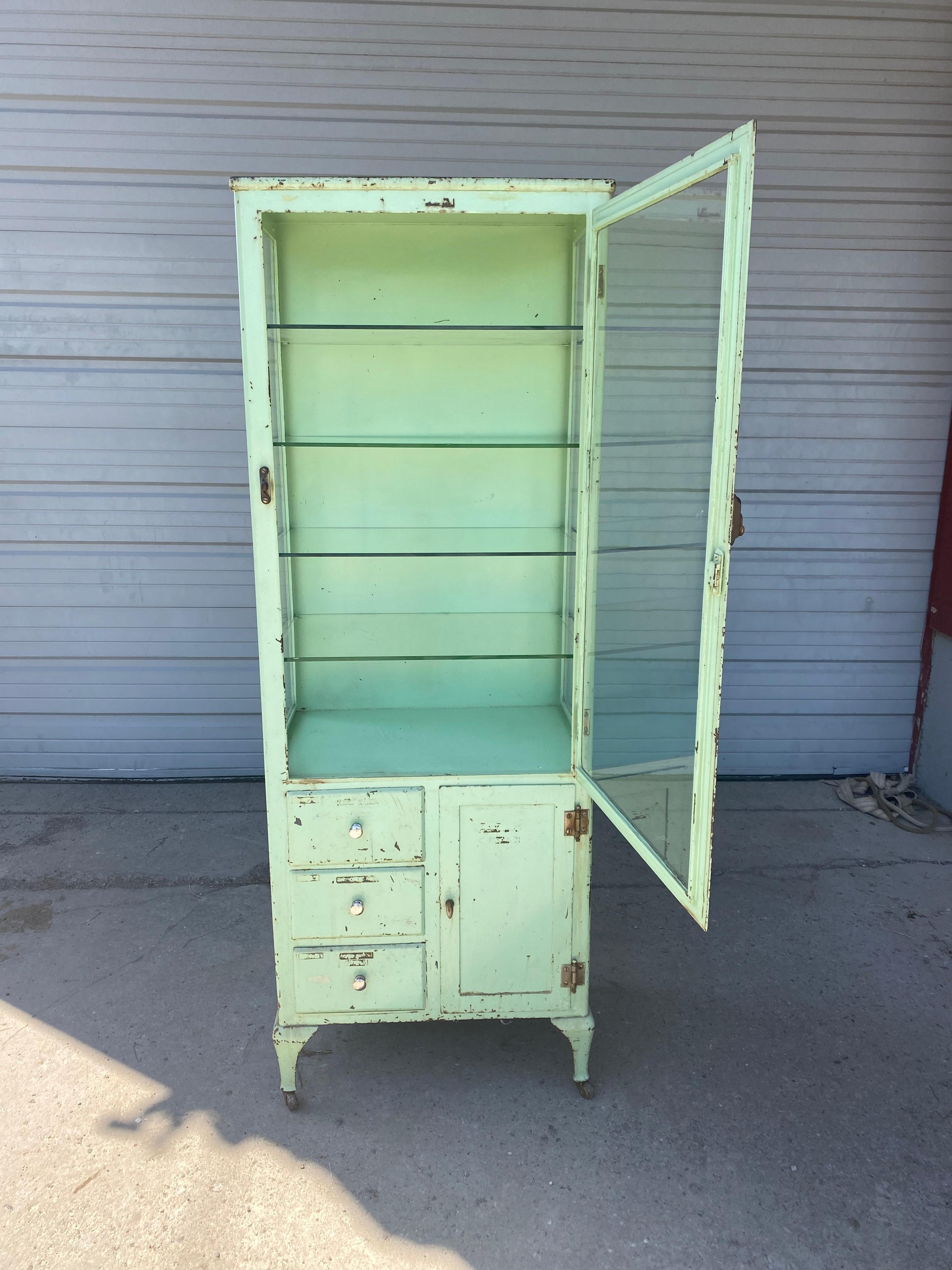 Classic Industrial / Architectural Medical, Dr's cabinet, storage, display, retains original green paint, surface, patina, nickel pulls, upper section, door 4 glass shelves. Lower section, 3 drawers, cubby, great for bathroom/ kitchen. Hand delivery