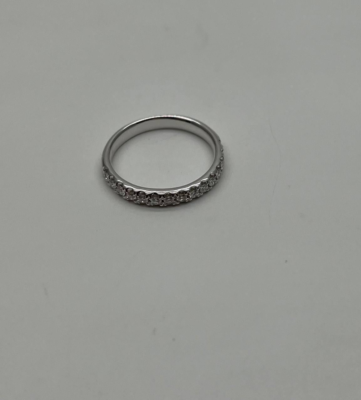 This elegant ring is crafted in 14K white gold. It features a row of brilliant-cut white diamonds, totaling 0.4 carats. The diamonds are set in a sleek band, showcasing their sparkle.
