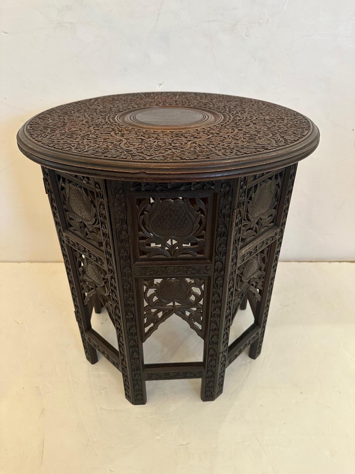 Classic Anglo Indian beautifully carved wood round side or end table having meticulous intricate details. Top is removeable and base folds in on itself for easy shipping.