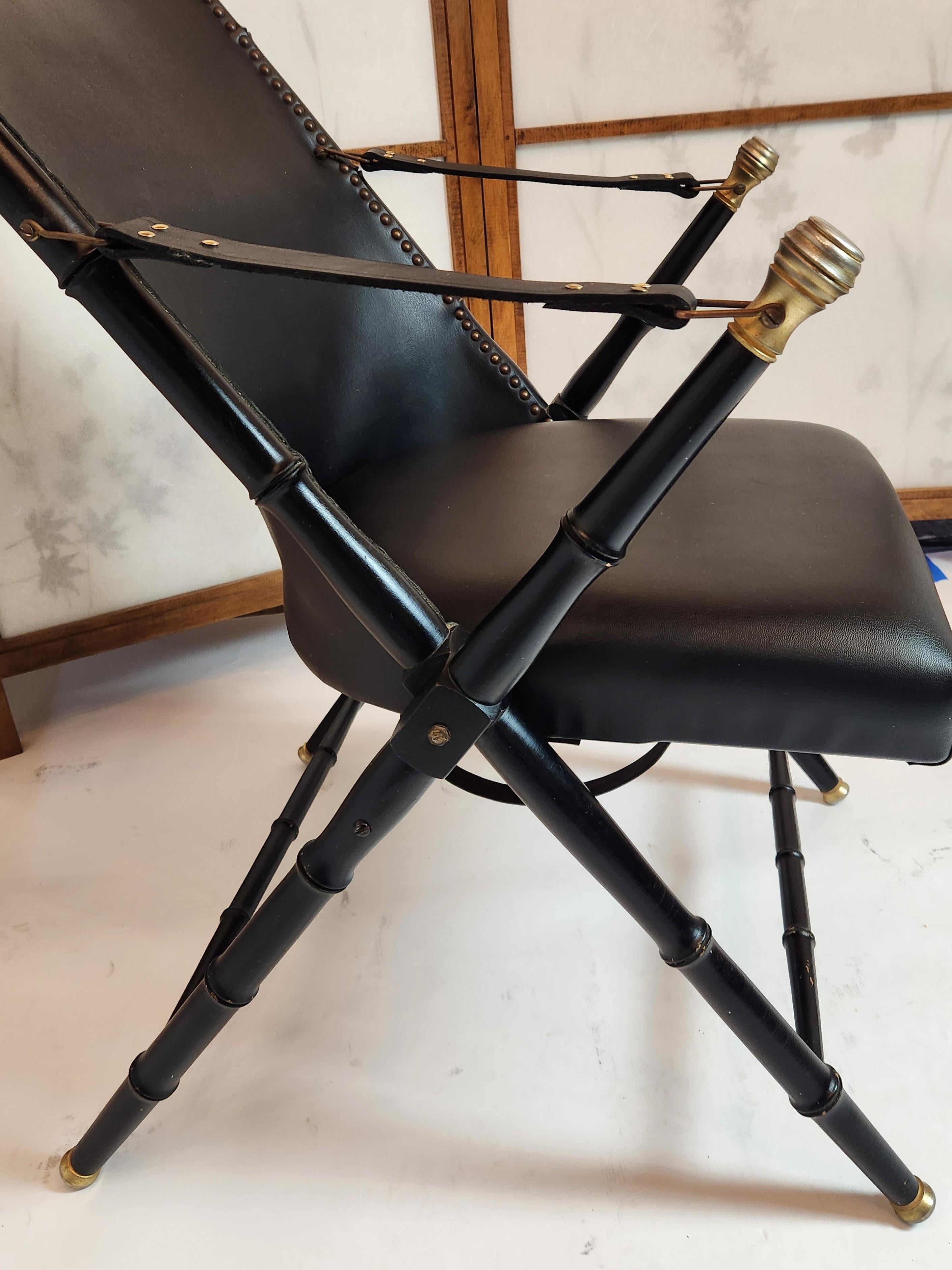 A classic Italian design, with an ebonized folding wood frame carved to appear as bamboo, cast brass caps, immaculate leather seat and back with brass nailhead trim, and newly re-done leather arm straps.
A beautiful chair in very good condition.