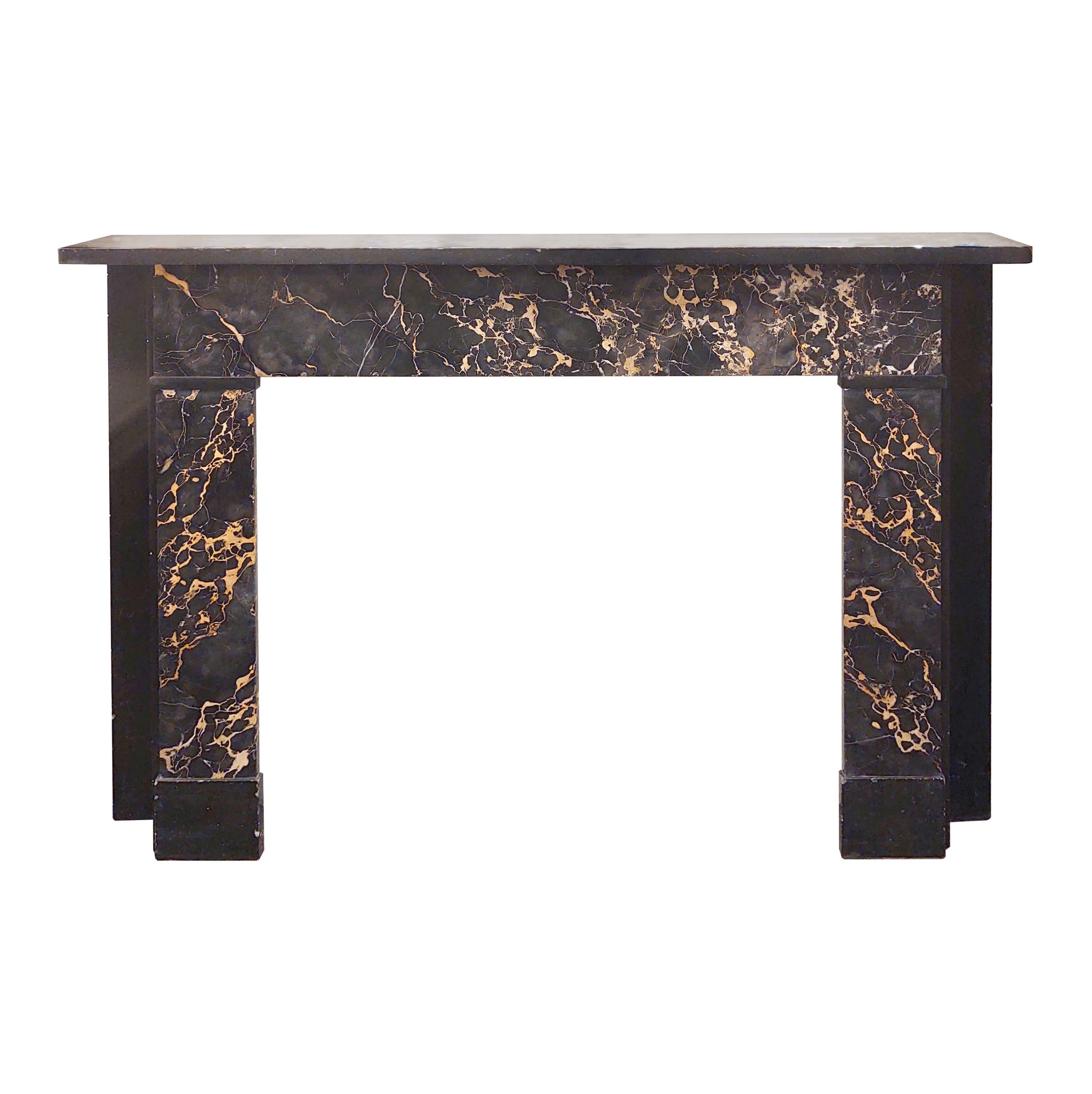 20th century Classic style marble mantel cut from Italian Portoro marble; known for its black and gold or black and silver veining. This mantle features Belgian black shelf and wall plates. Retrieved from a townhouse located in the West Village