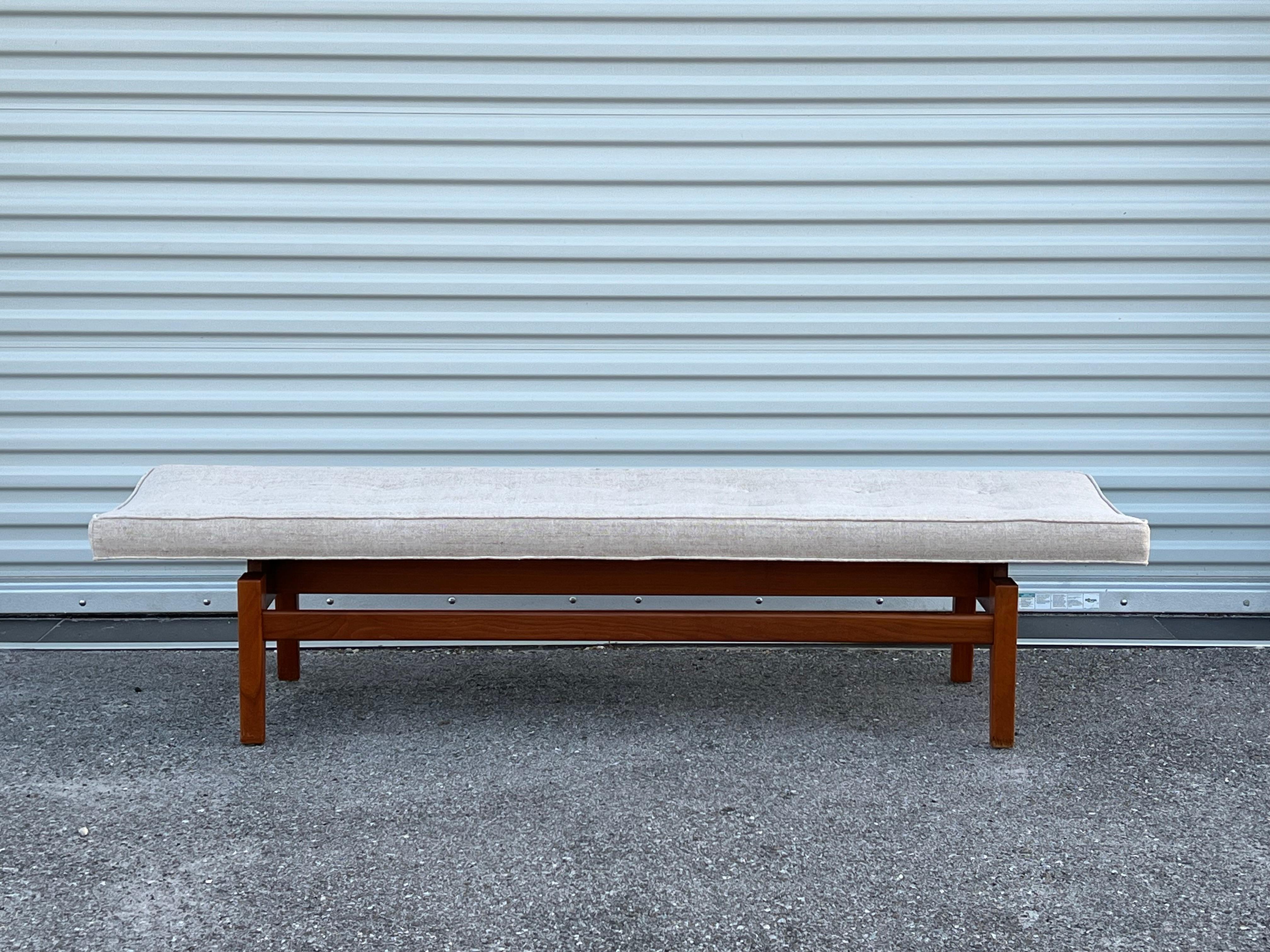 A Classic Jens Risom six foot long, upholstered, floating bench. Walnut frame with natural, raw linen/silk upholstery. Note-this is a lighter wood-walnut version.