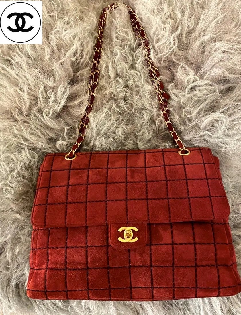 Classic Chanel Knit Flap Burgundy Shoulder bag Handbag.
Beautiful knit black design with gold CC accent in front and the burgundy suede extends to the leather strap with gold chain accents. 

The interior is a clean Burgundy leather that has one